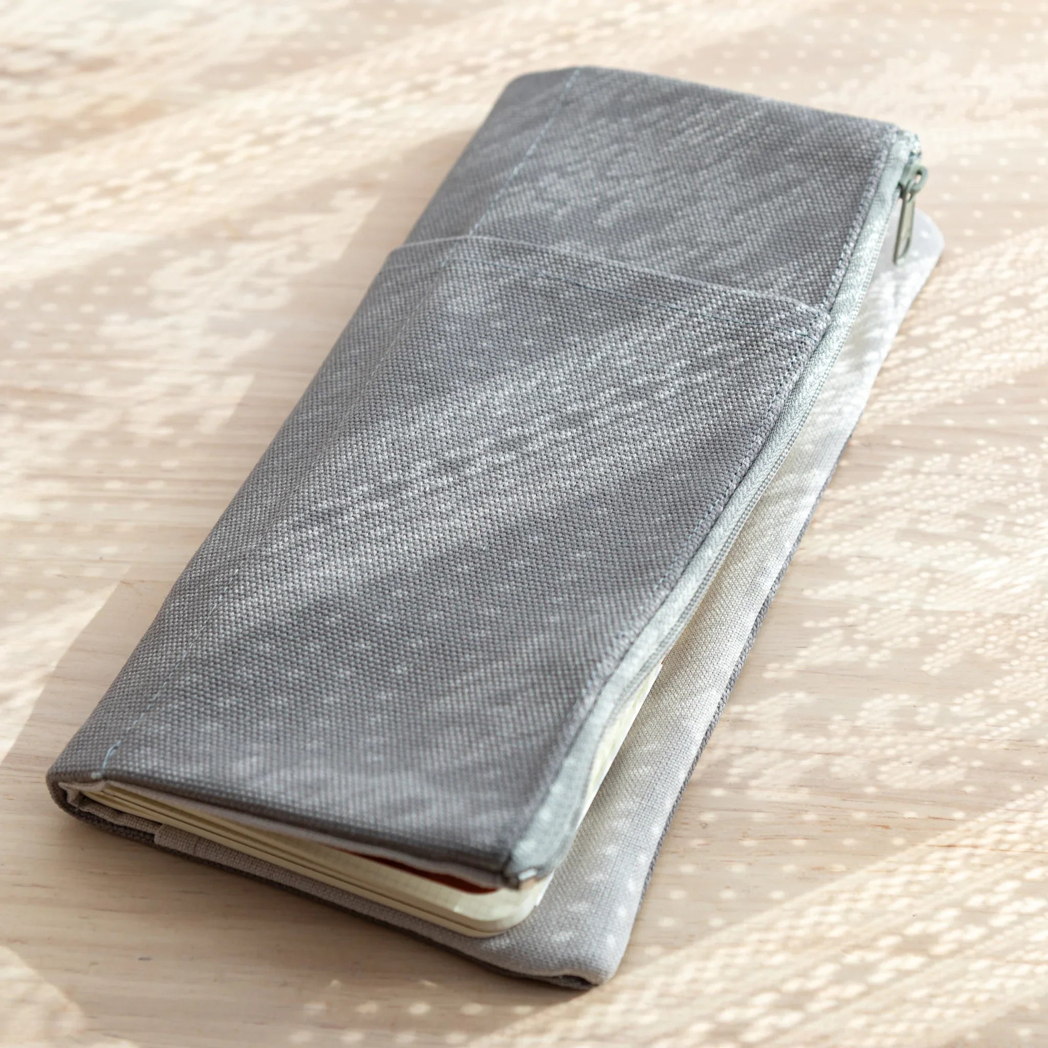 Cool Gray canvas cover with zipper closed, housing RO-BIKI Japanese Note Book, minimal and neat design.
