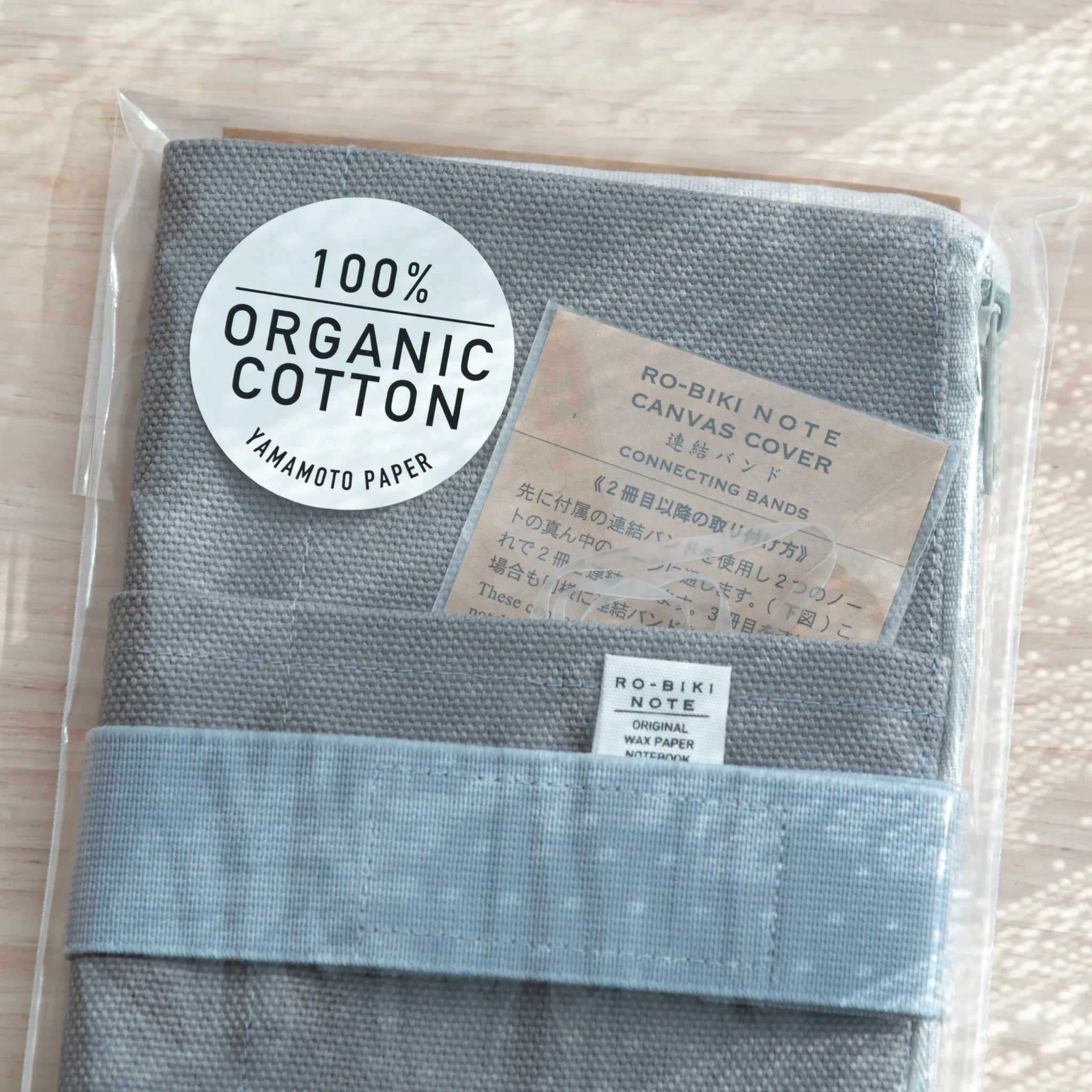 Instruction sheet on RO-BIKI Canvas Cover Cool Gray packaging, showing usage with Japanese Note Book and pens.