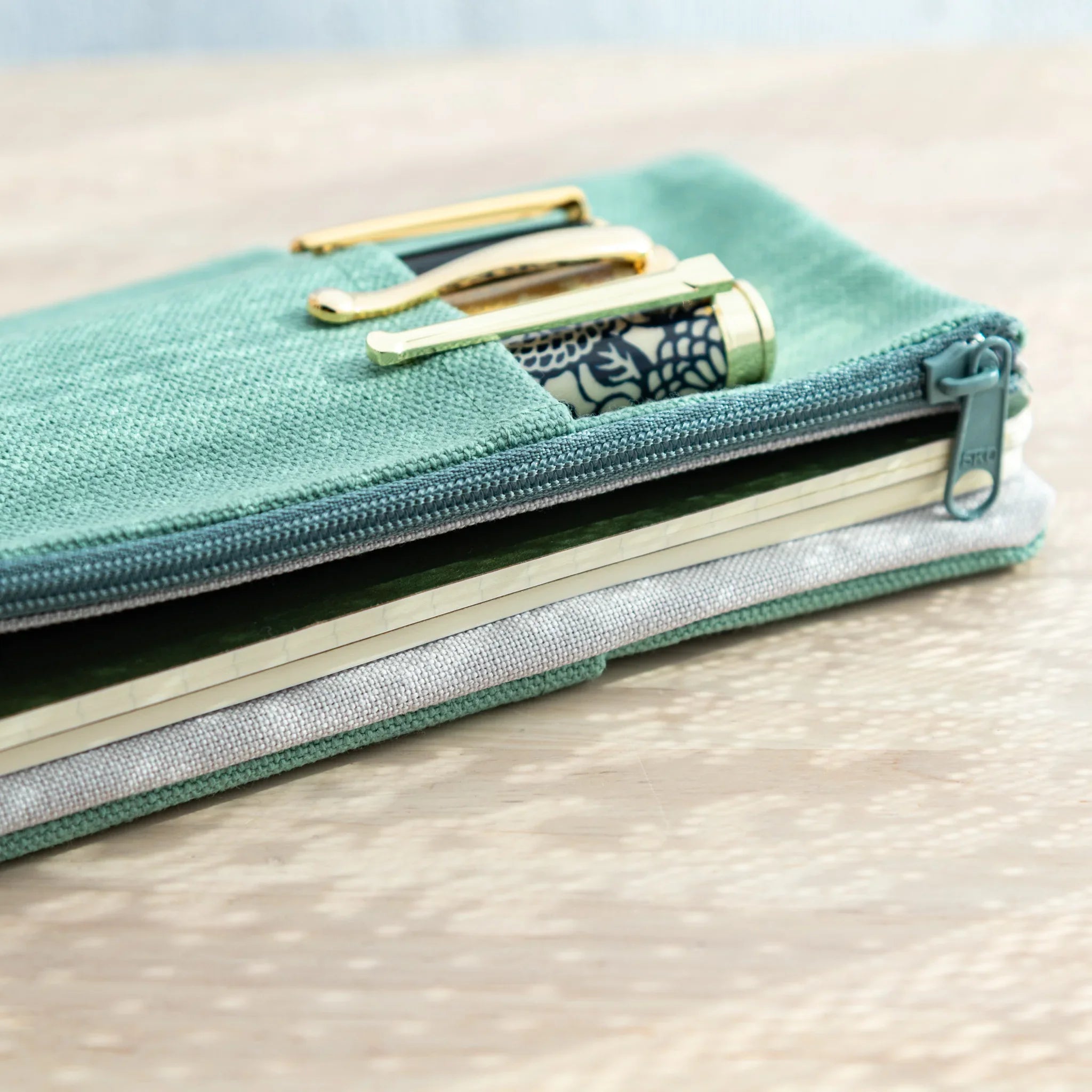 Close-up of the cover, showing zipper partially open with notebooks and Japanese Fountain Pens inside, Japanese Notebook Cover.