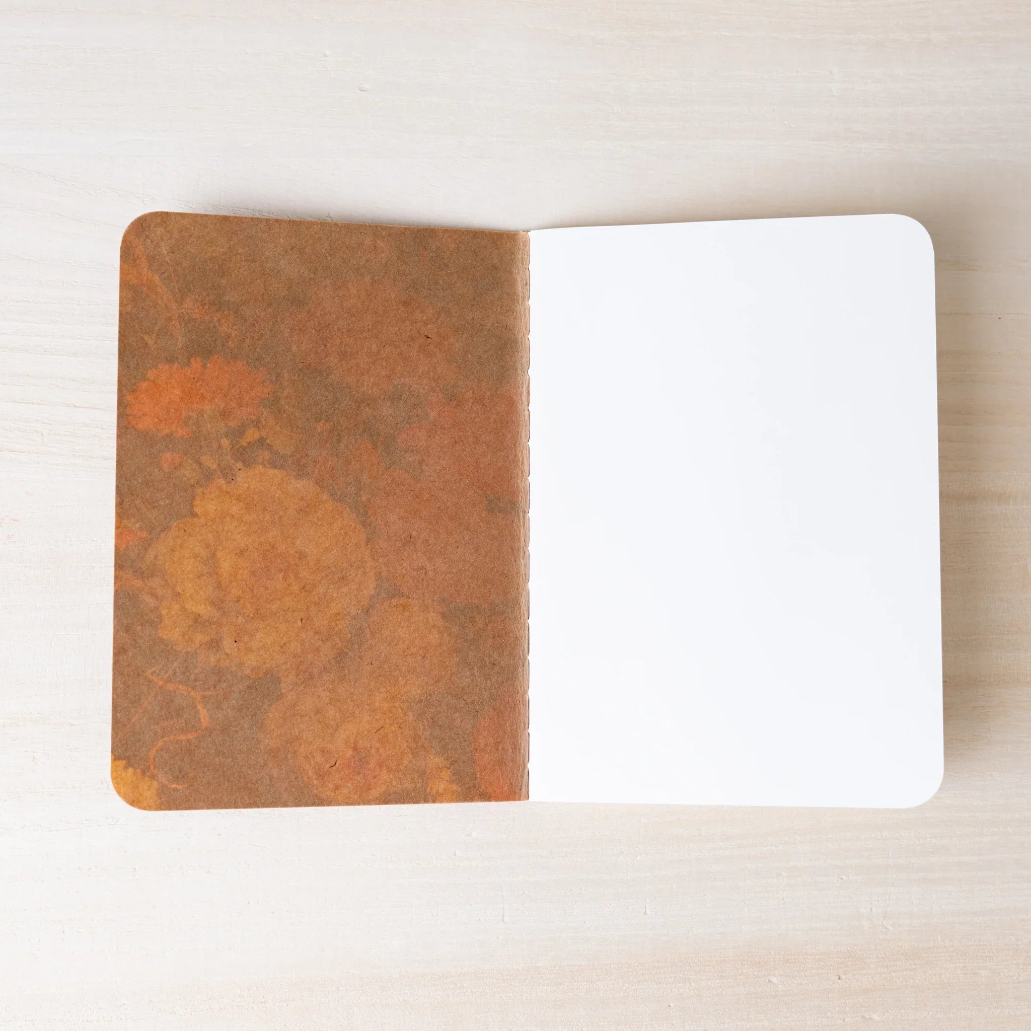 RO-BIKI NOTE Japanese notebook open flat, brown waxed kraft inner cover on left, blank white page on right, rounded corners