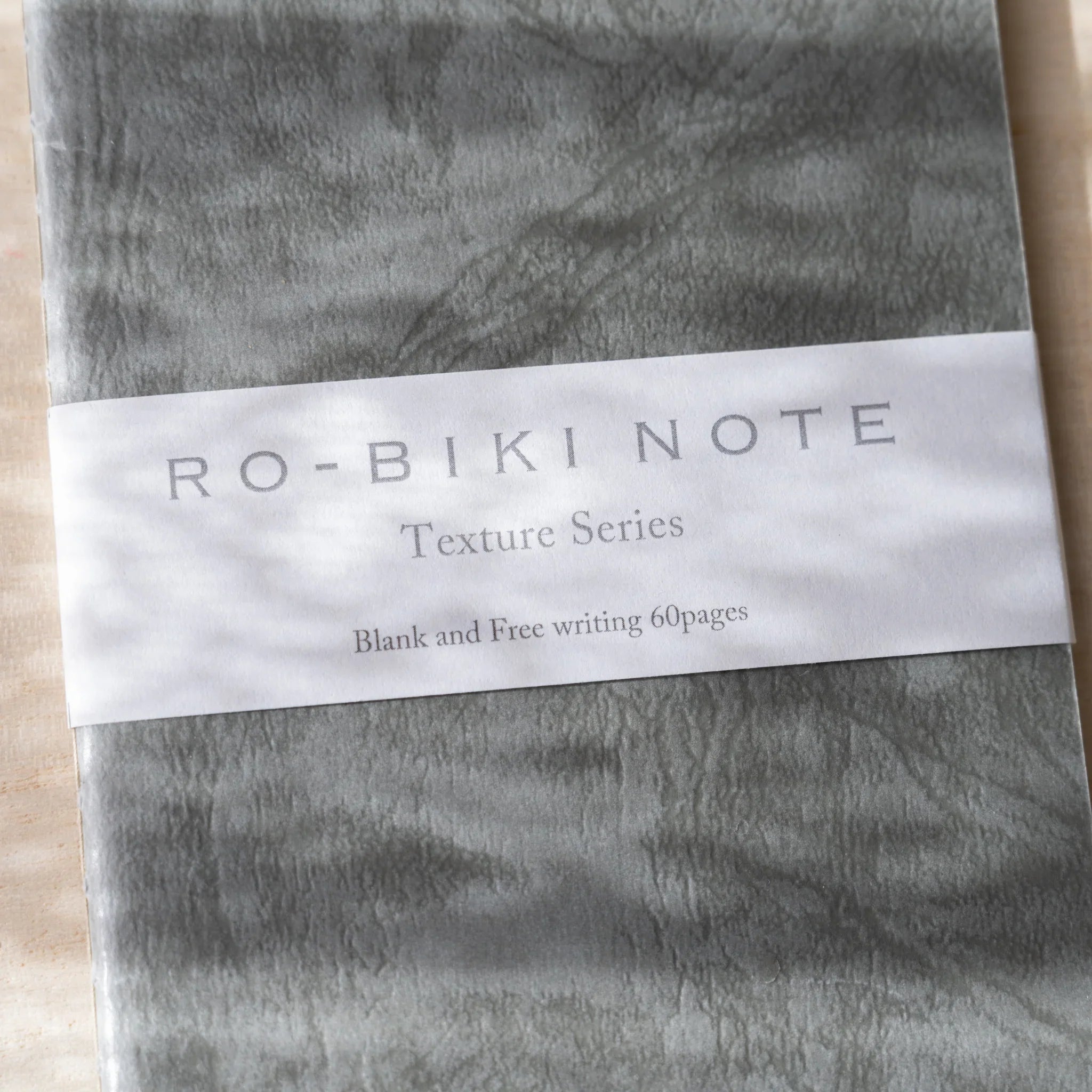 Close-up of RO-BIKI NOTE Texture Series label showing Blank and Free writing 60 pages on Ginnezu gray notebook