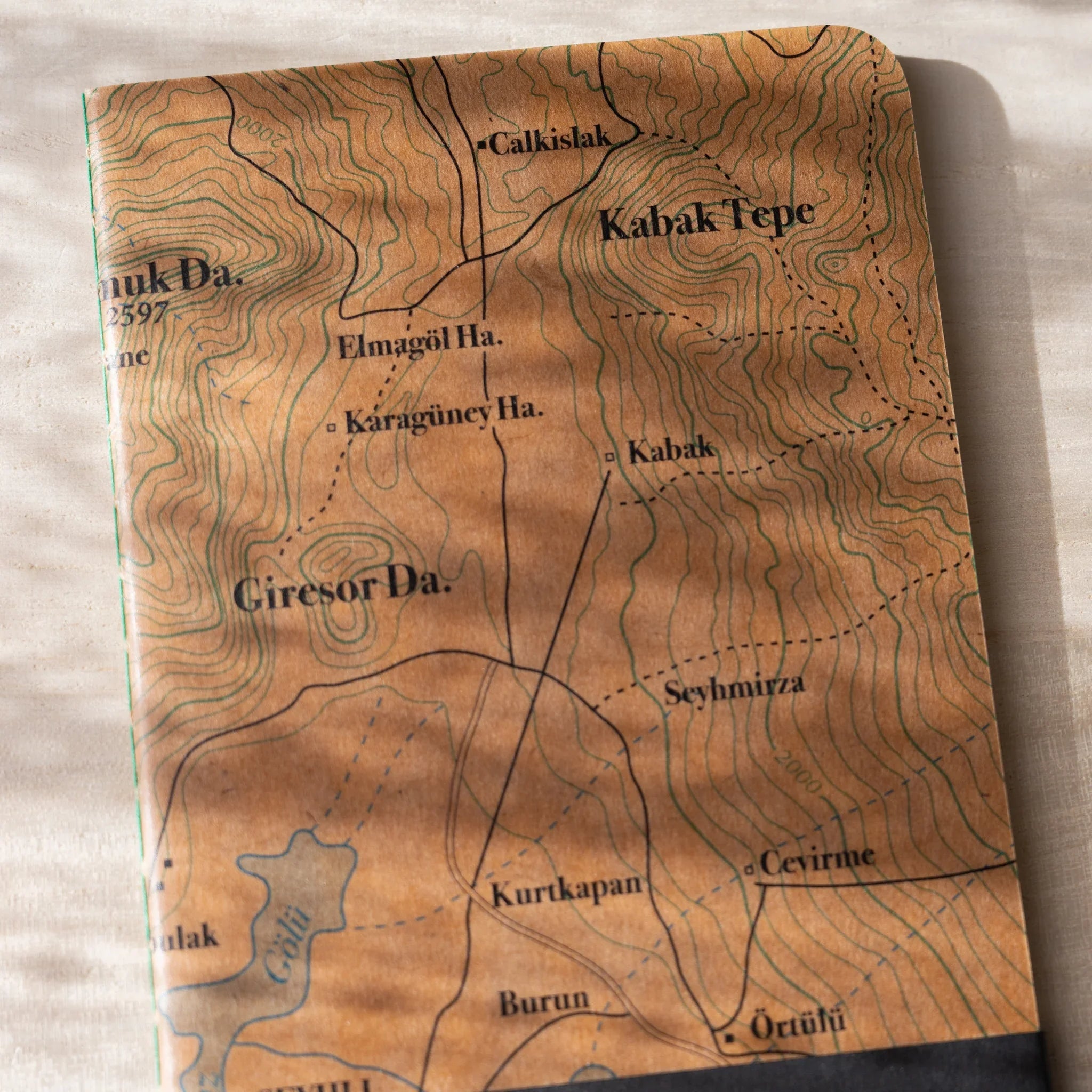 Detailed close-up of RO-BIKI NOTE wax-coated cover with topographical map contour lines and elevation markings