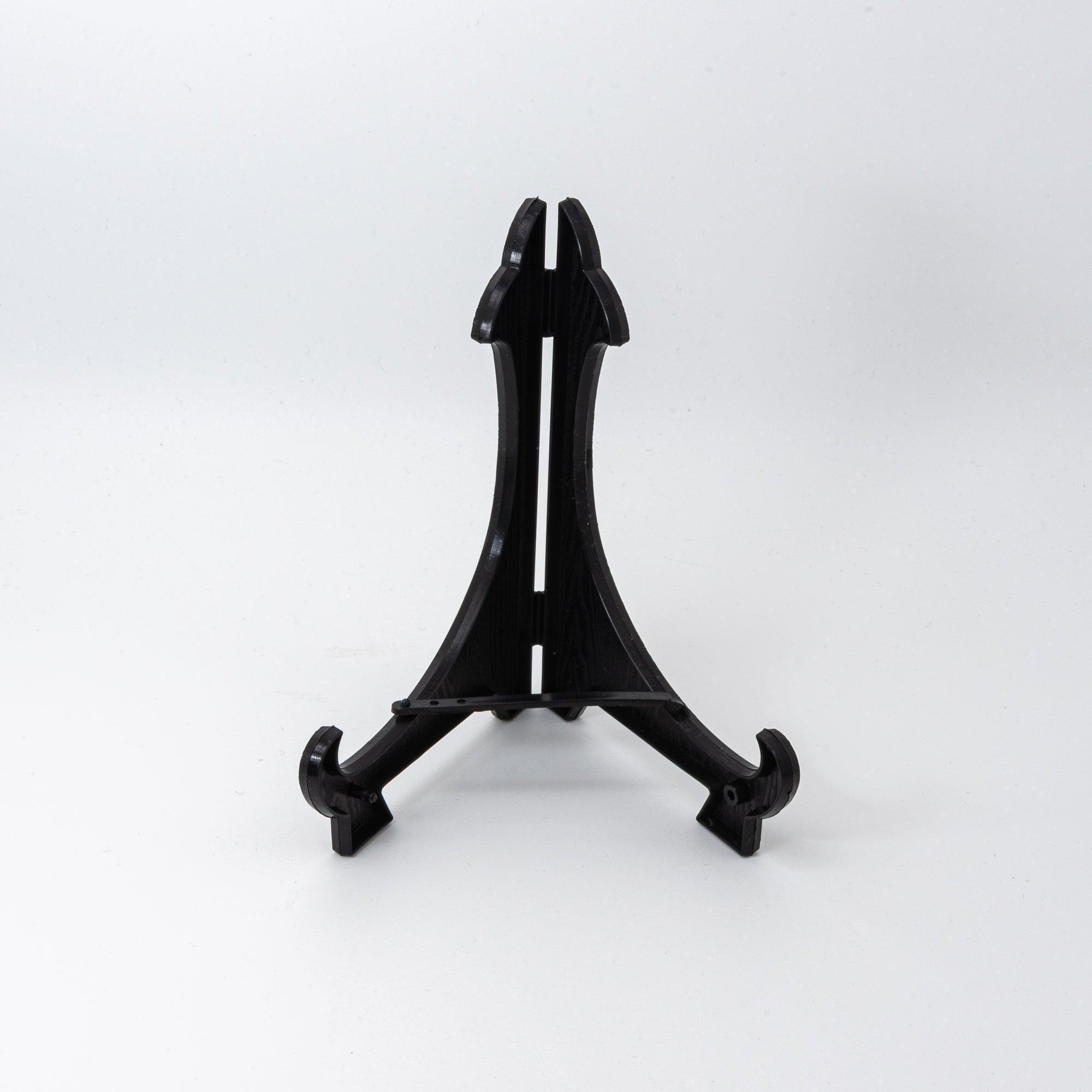 Black plastic display stand with a curved design for holding decorative items upright.  