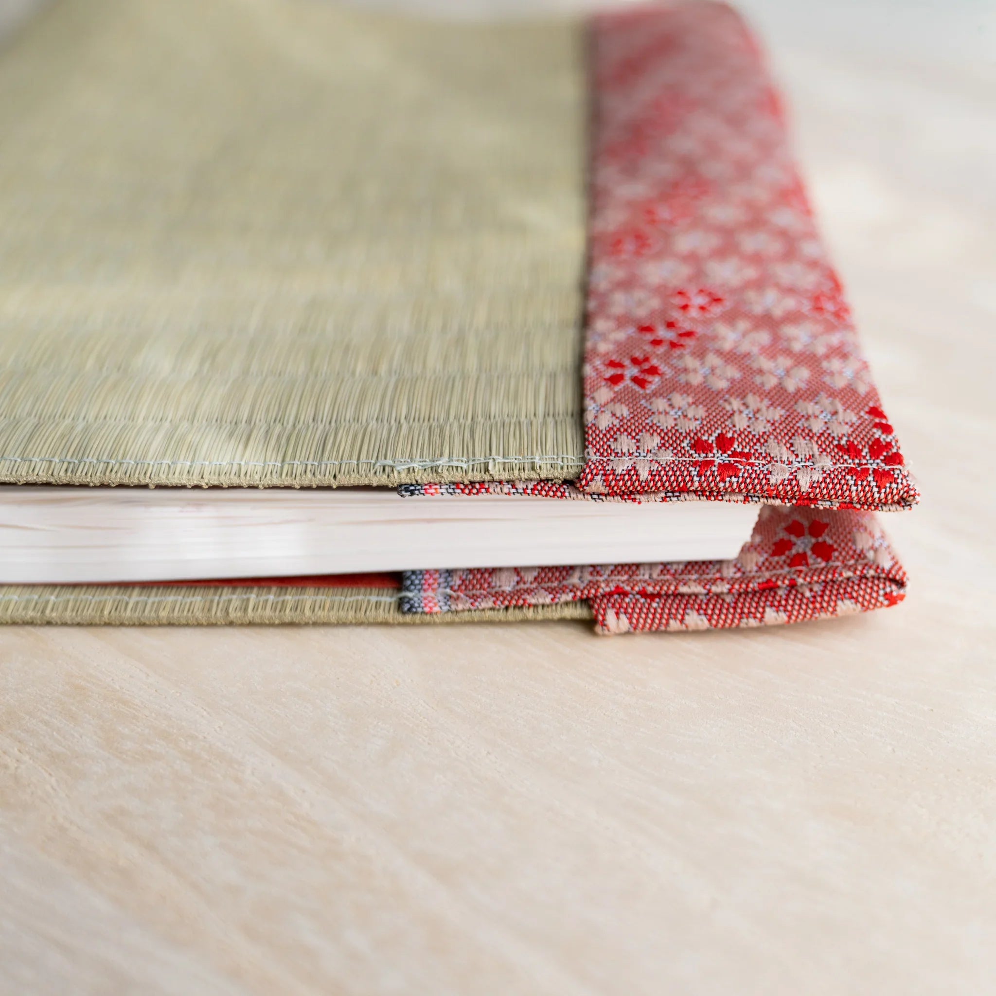 Side view of tatami book cover with notebook inserted, showing thickness and folded cherry blossom fabric flap