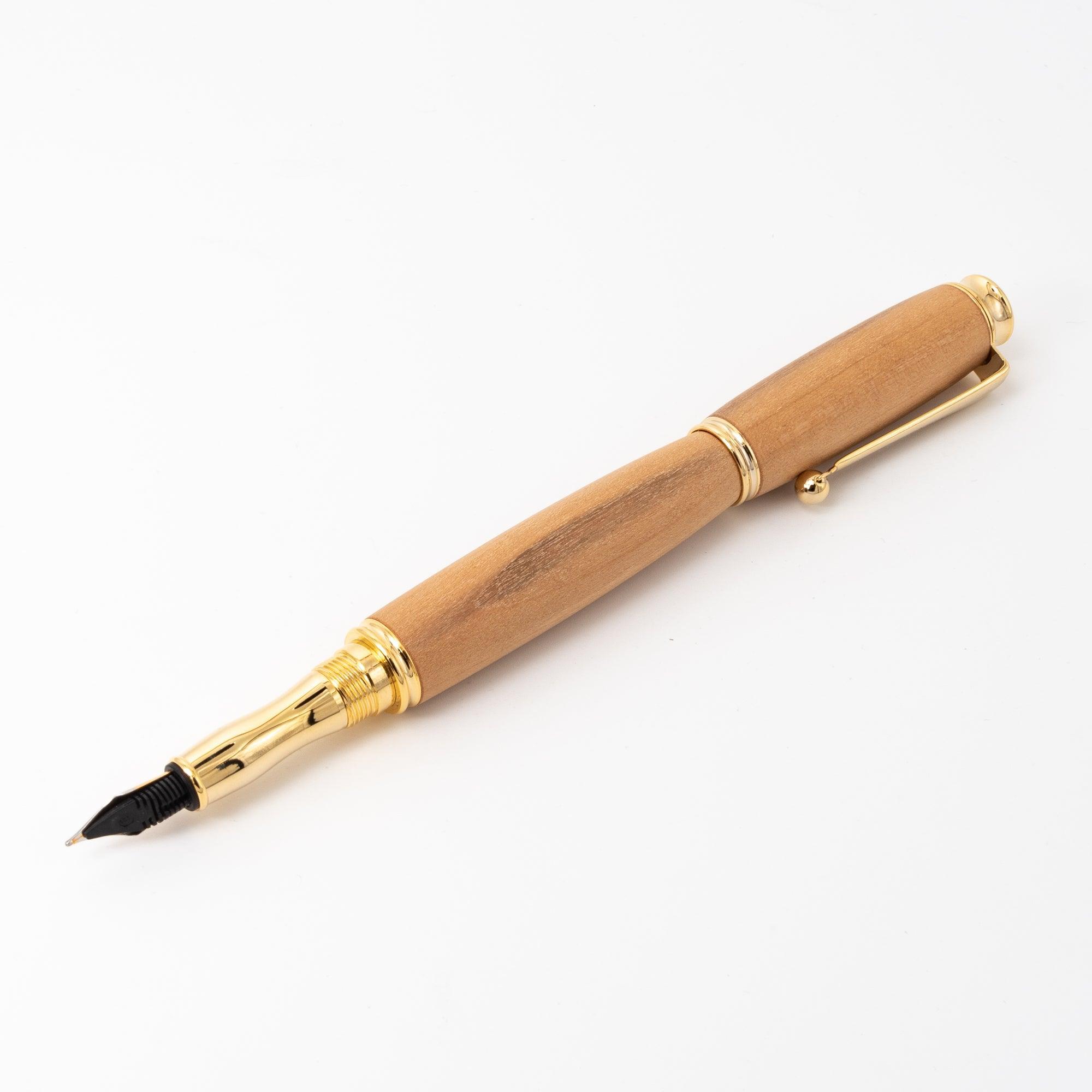 A Japanese fountain pen with a wooden body, black nib, and gold accents, elegantly placed on a white surface for a clean and modern presentation.