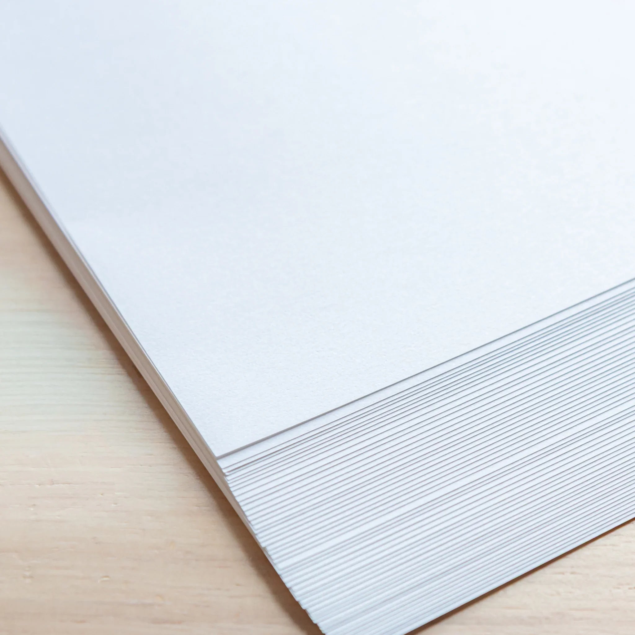 Stacked edge view of Slight White Japanese Loose Leaf Paper A4, showing cleanly cut 50 sheets with smooth texture.