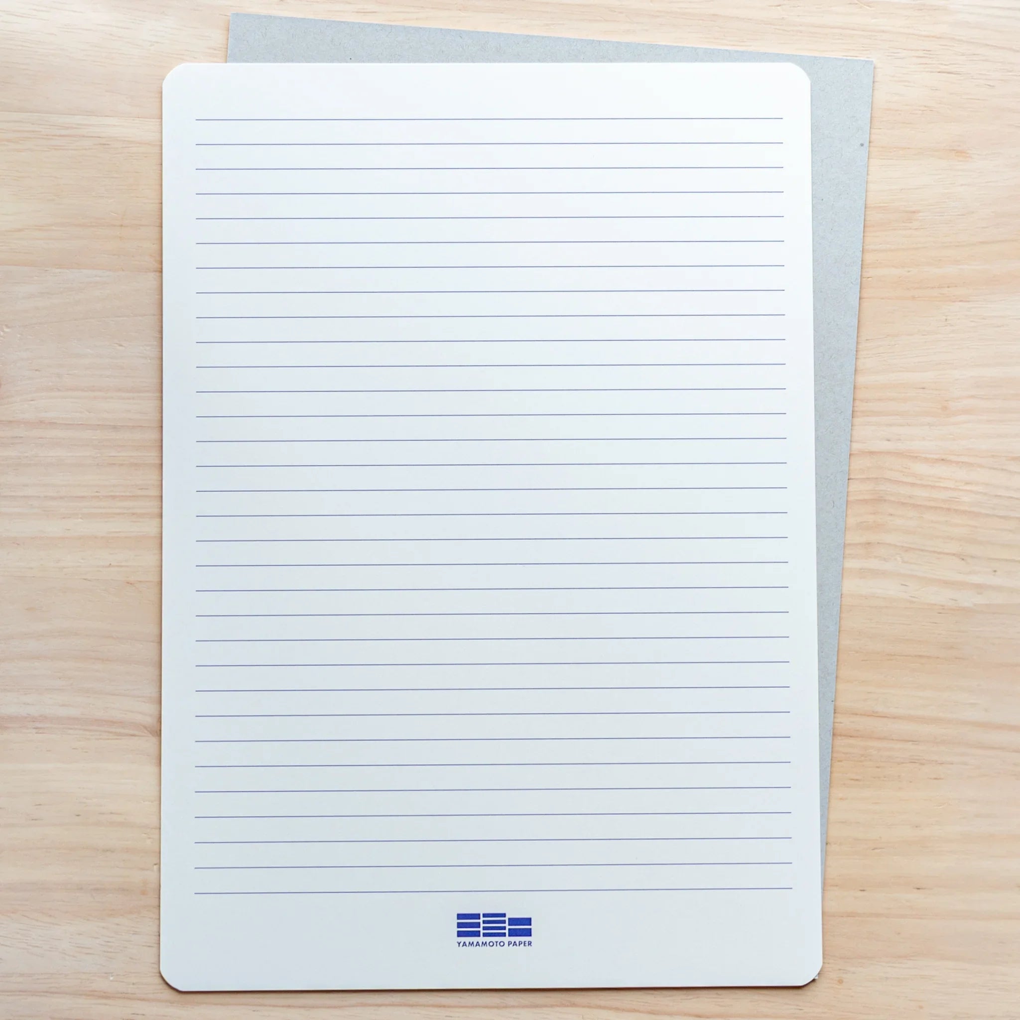 A4 Slight White Japanese Loose Leaf Paper, shown with clear horizontal ruled underlay for precise writing.