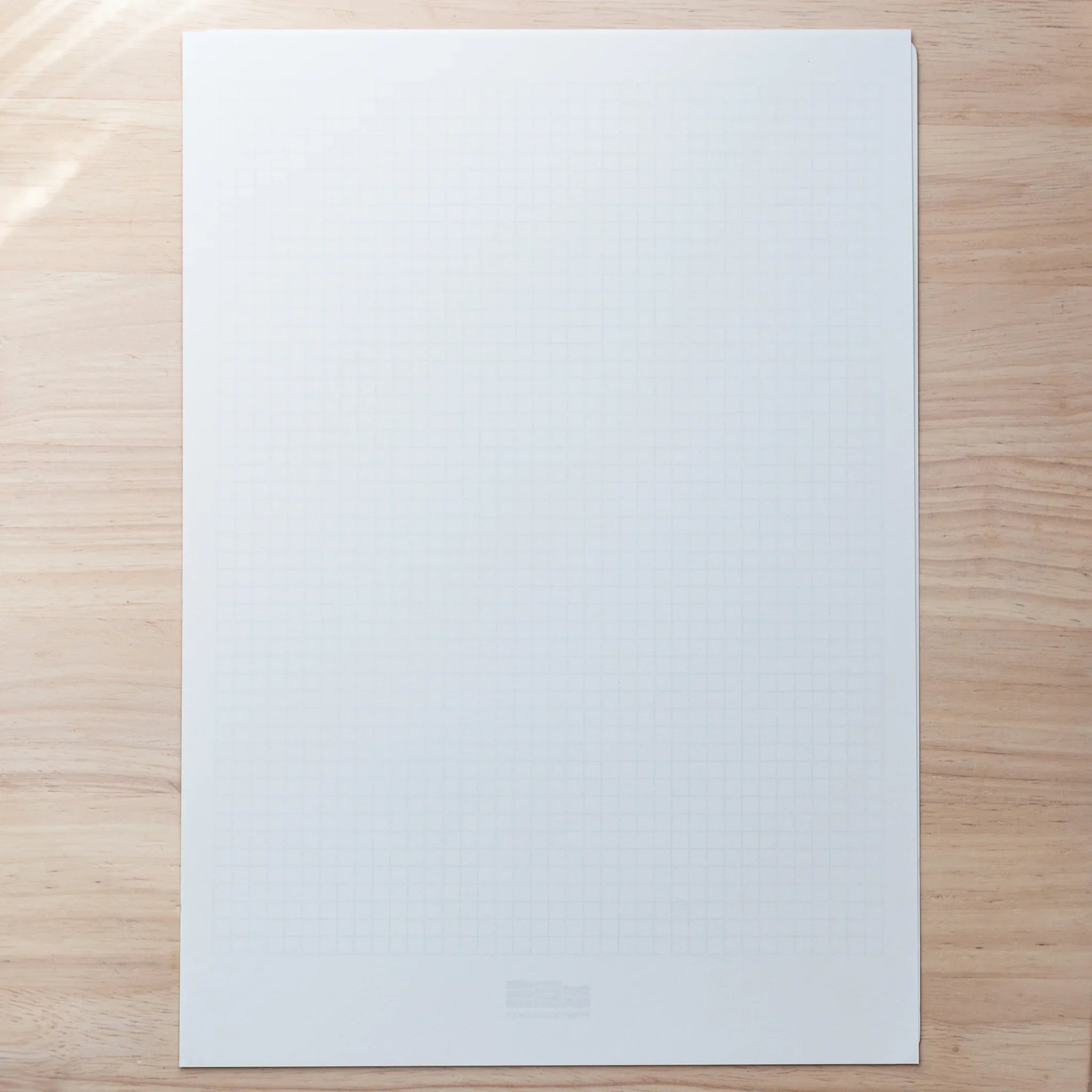A4 Slight White Japanese Loose Leaf Paper sheet with blue grid underlay, perfect for writing and pen testing.
