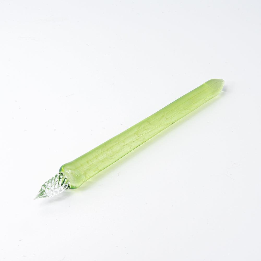 Simple green glass pen with clear swirling nib, placed on a clean white background. Its elegant and sleek design catches the light.