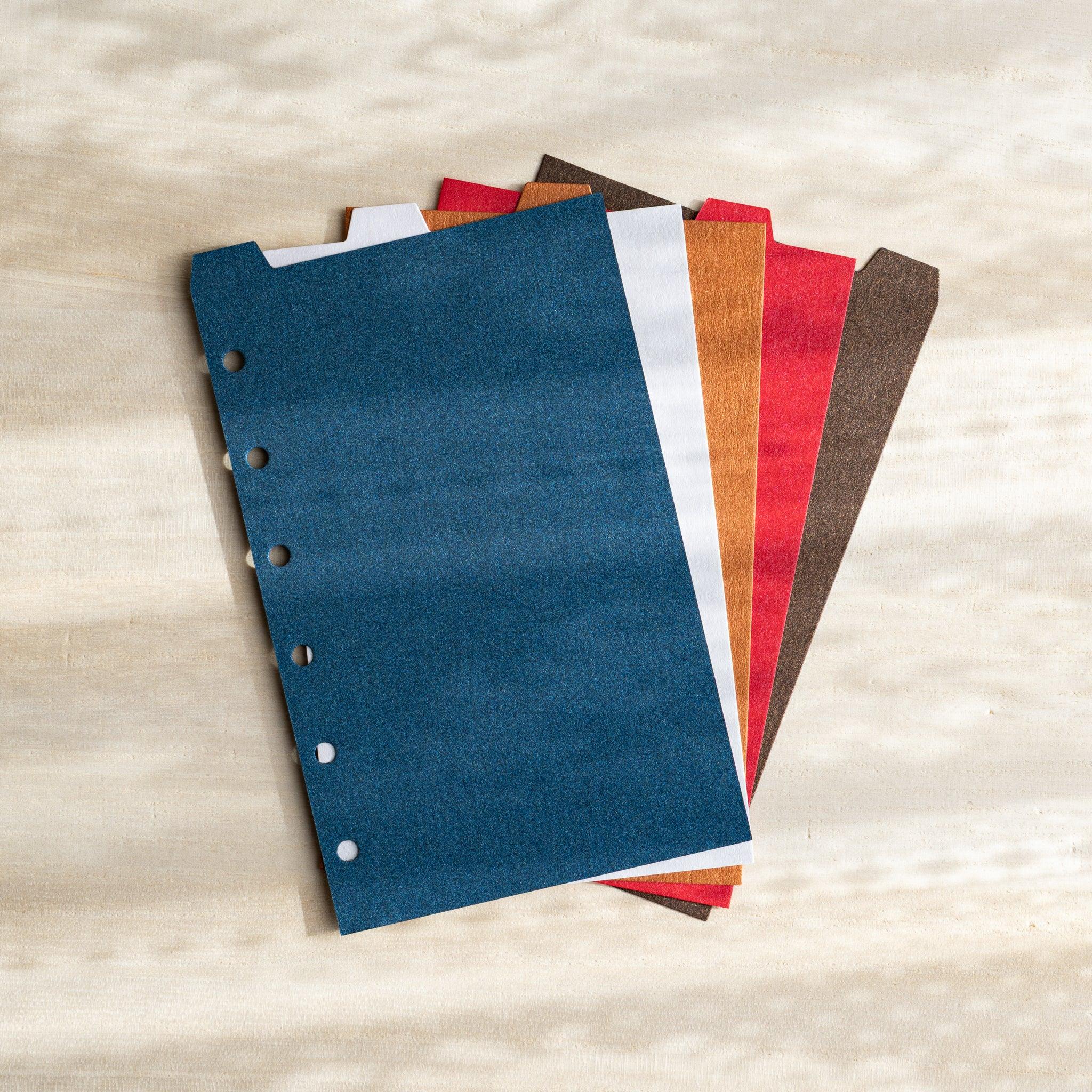 Japanese Stationery Stardream top-tab index dividers for Mini 6 planners in assorted colors, stacked neatly on a surface.