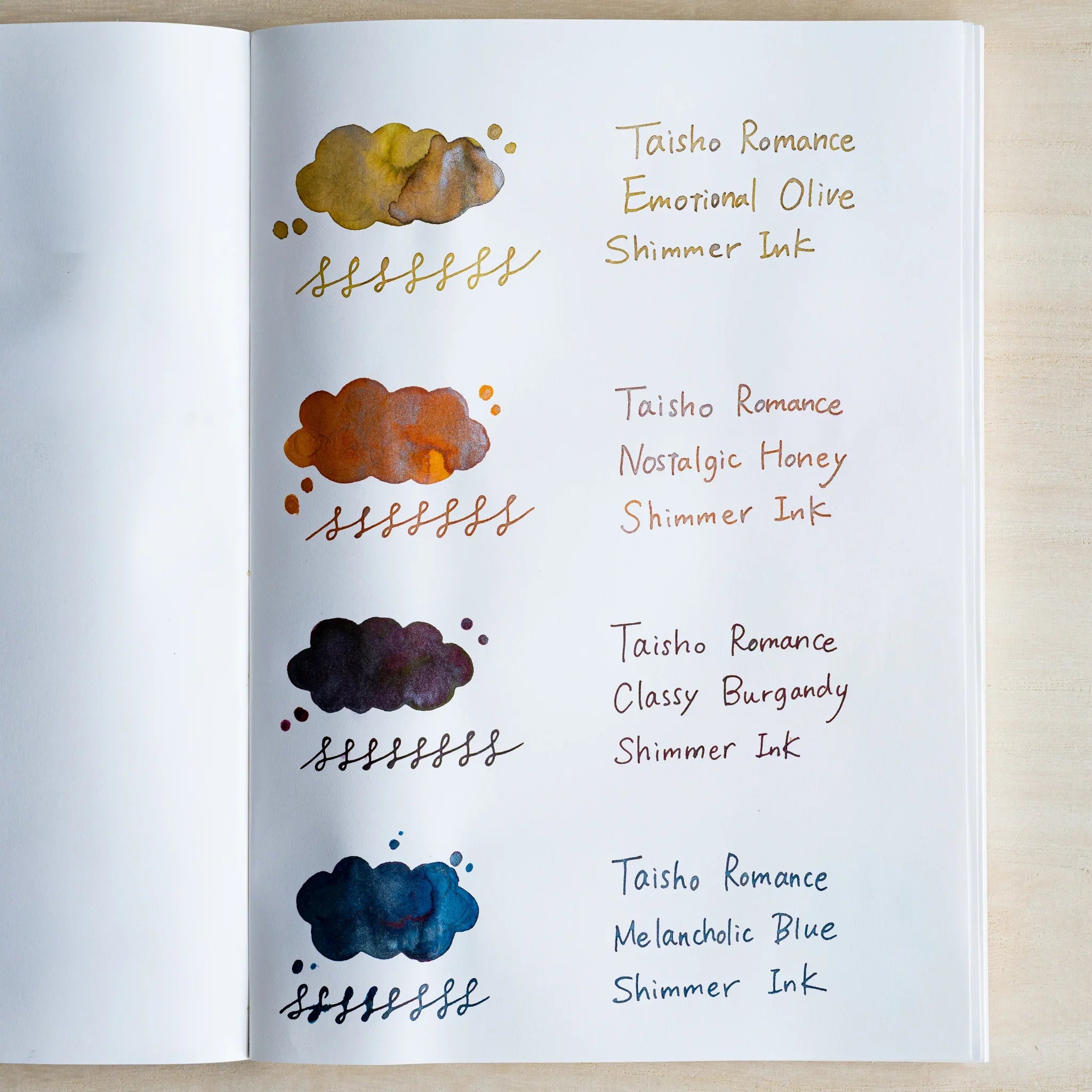 Notebook page of handwritten swatches for the four Taisho Romance shimmer inks, washes with silver flecks
