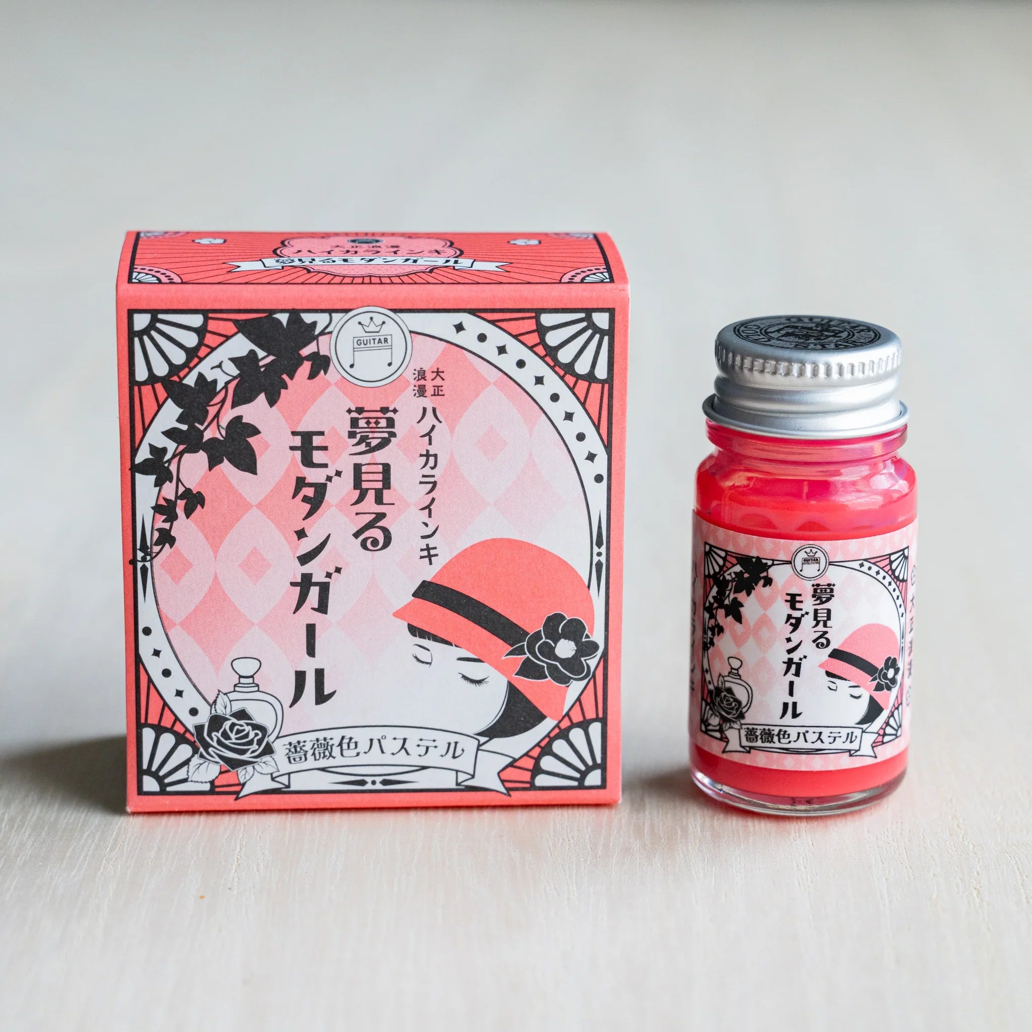 Taisho Romance Rose Pastel ink box in coral pink beside a 12 ml glass bottle of opaque coral pink pigment ink