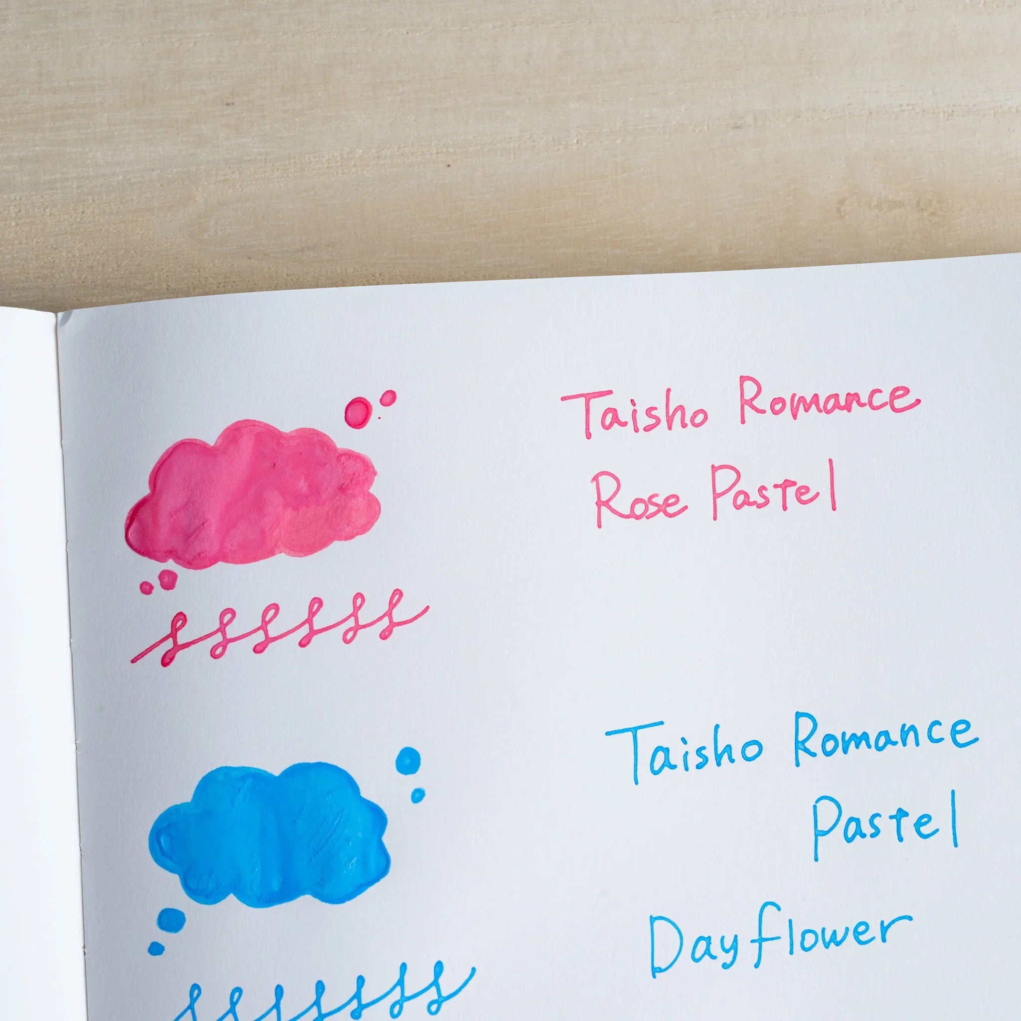 Handwritten swatch of Taisho Romance Rose Pastel ink, a cloud-shaped wash and a looped line in coral pink