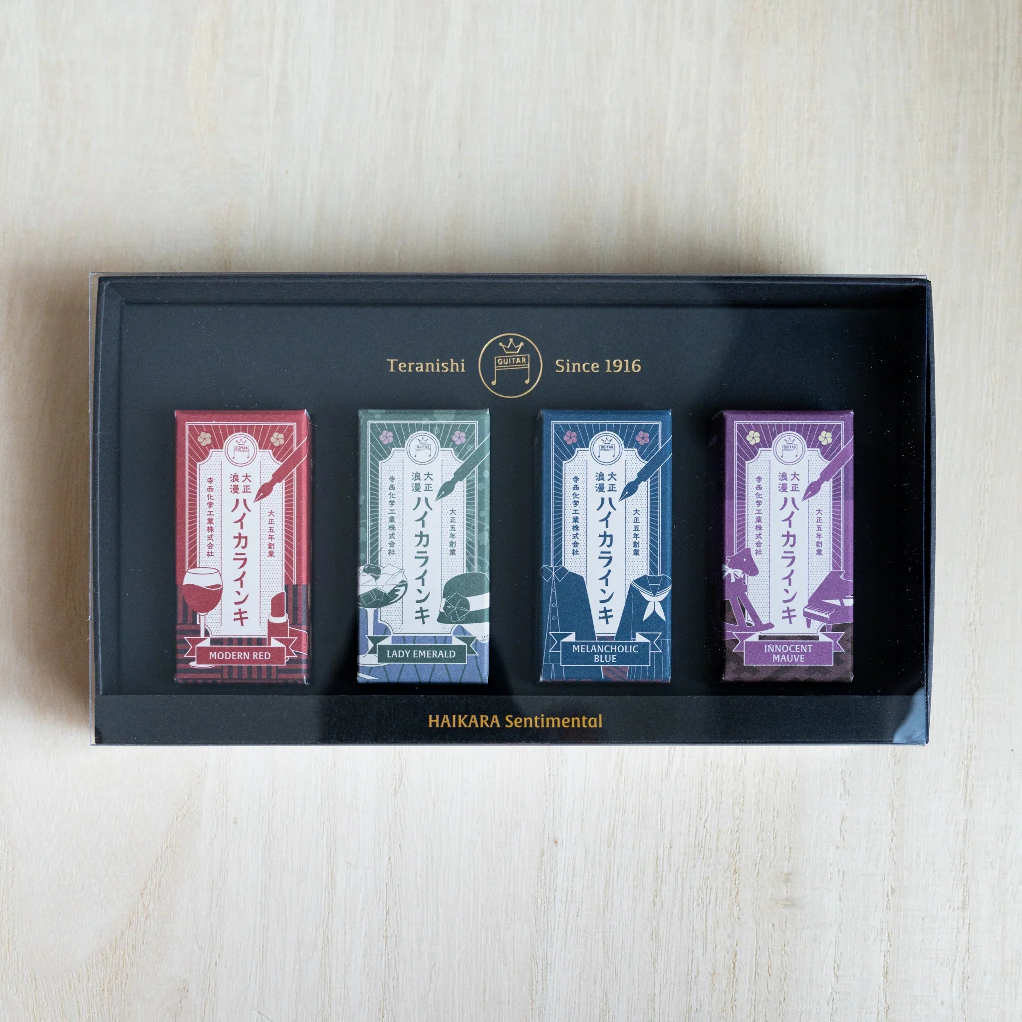 Open black gift box of the HAIKARA Sentimental set with four individually wrapped 12 ml ink bottles inside
