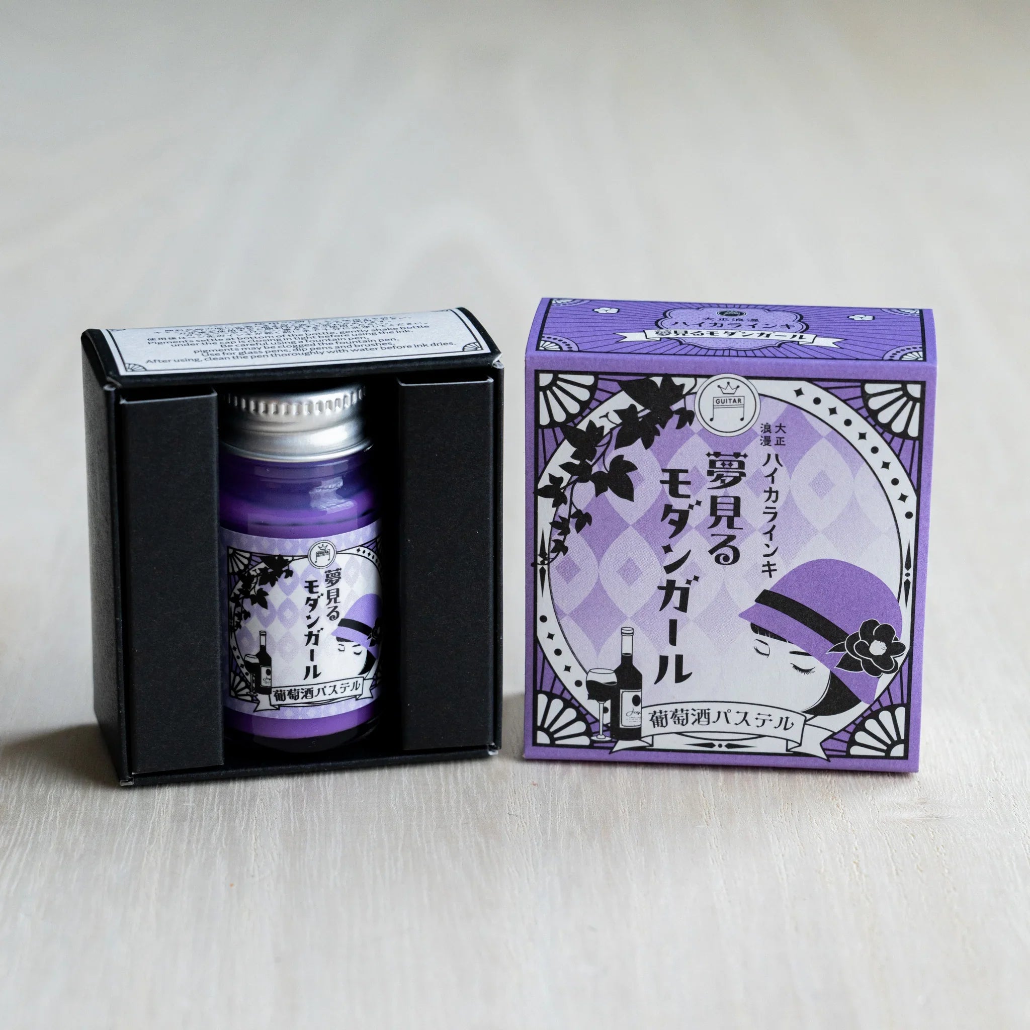 Taisho Romance Wine Pastel ink bottle in its open black inner box, next to the closed lavender outer box