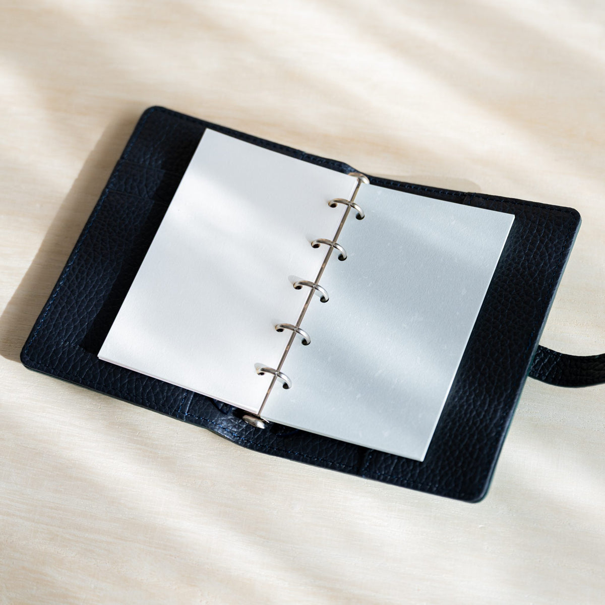 Open navy planner with white and light blue Feather Waltz M5 refill pages