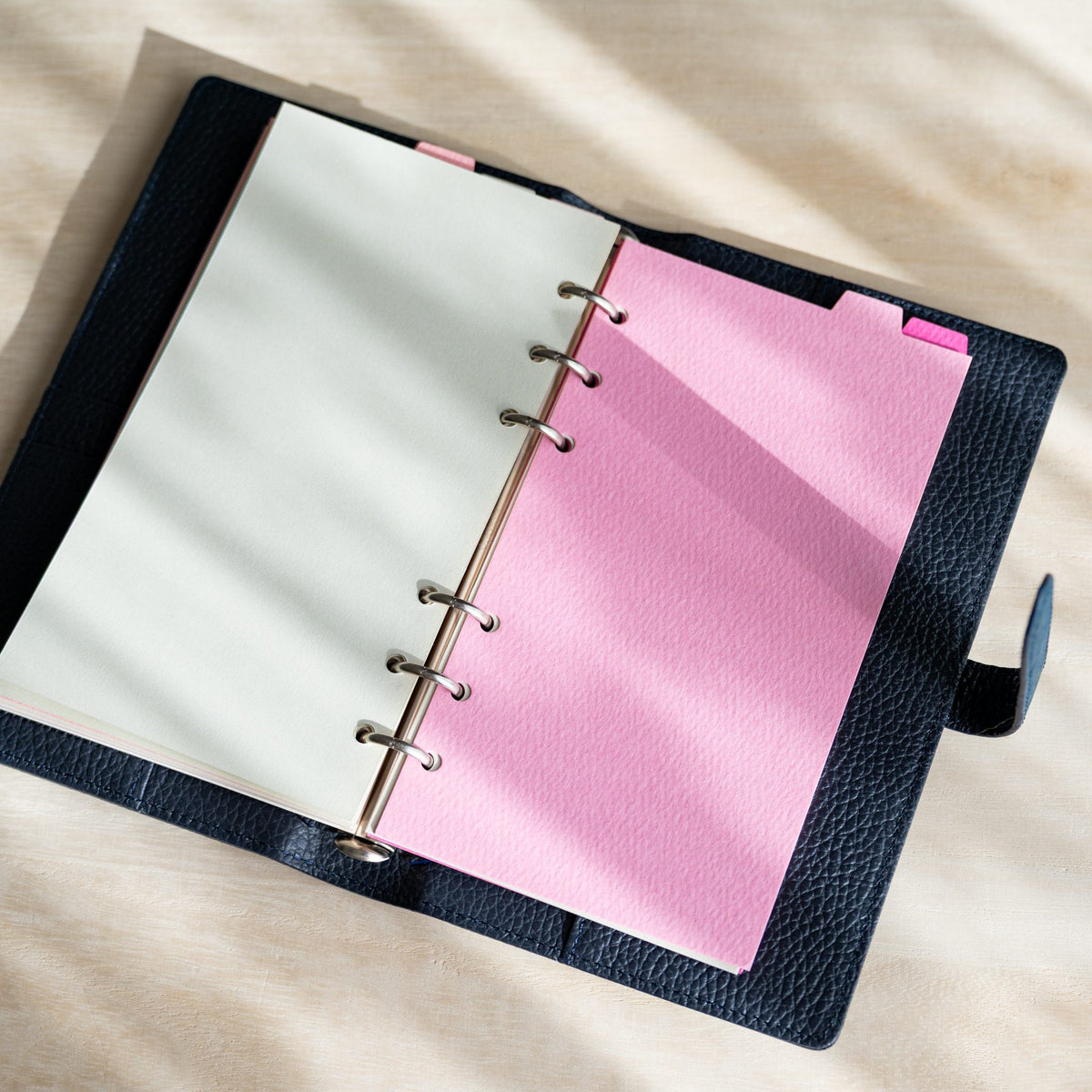 Bright pink Mermaid Bible divider opposite a cream page in an open navy planner