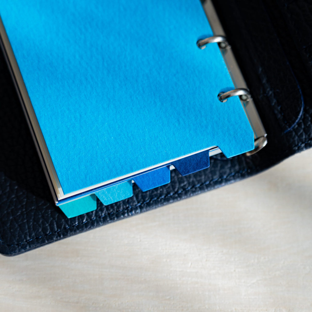 Mermaid M5 blue dividers in a navy planner with staggered blue and turquoise tabs