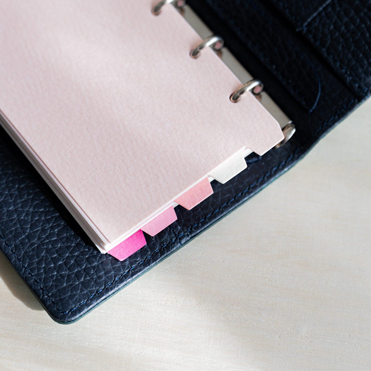 Mermaid M5 pink dividers in a navy planner with staggered pink and white tabs