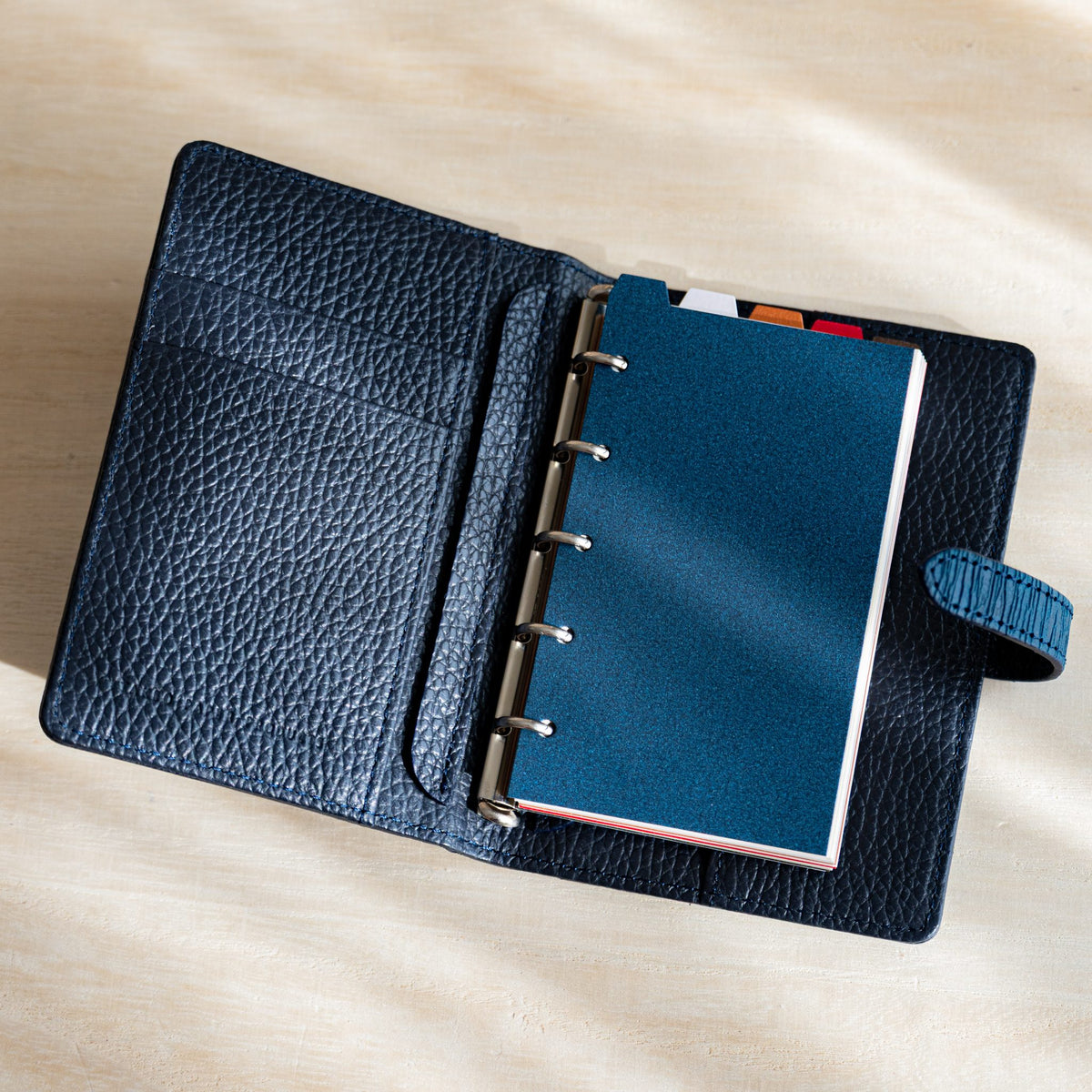 Night blue Stardream M5 index divider on the silver rings of an open navy grained leather planner