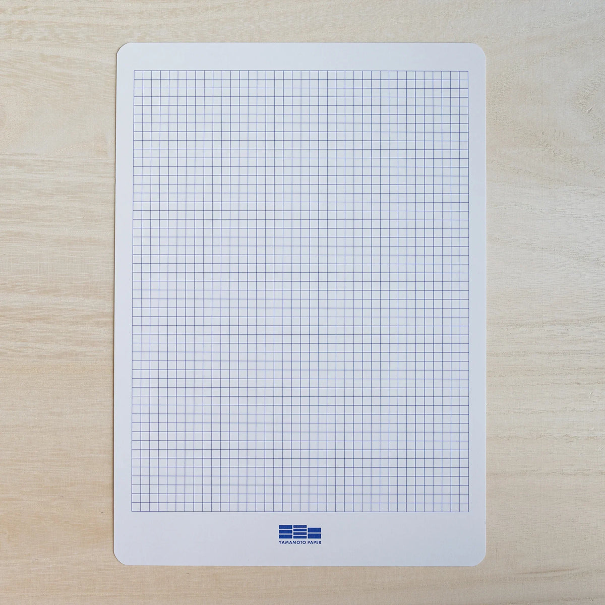 Yamamoto Paper grid guide sheet with a blue square grid, included with Tateyama A4 paper