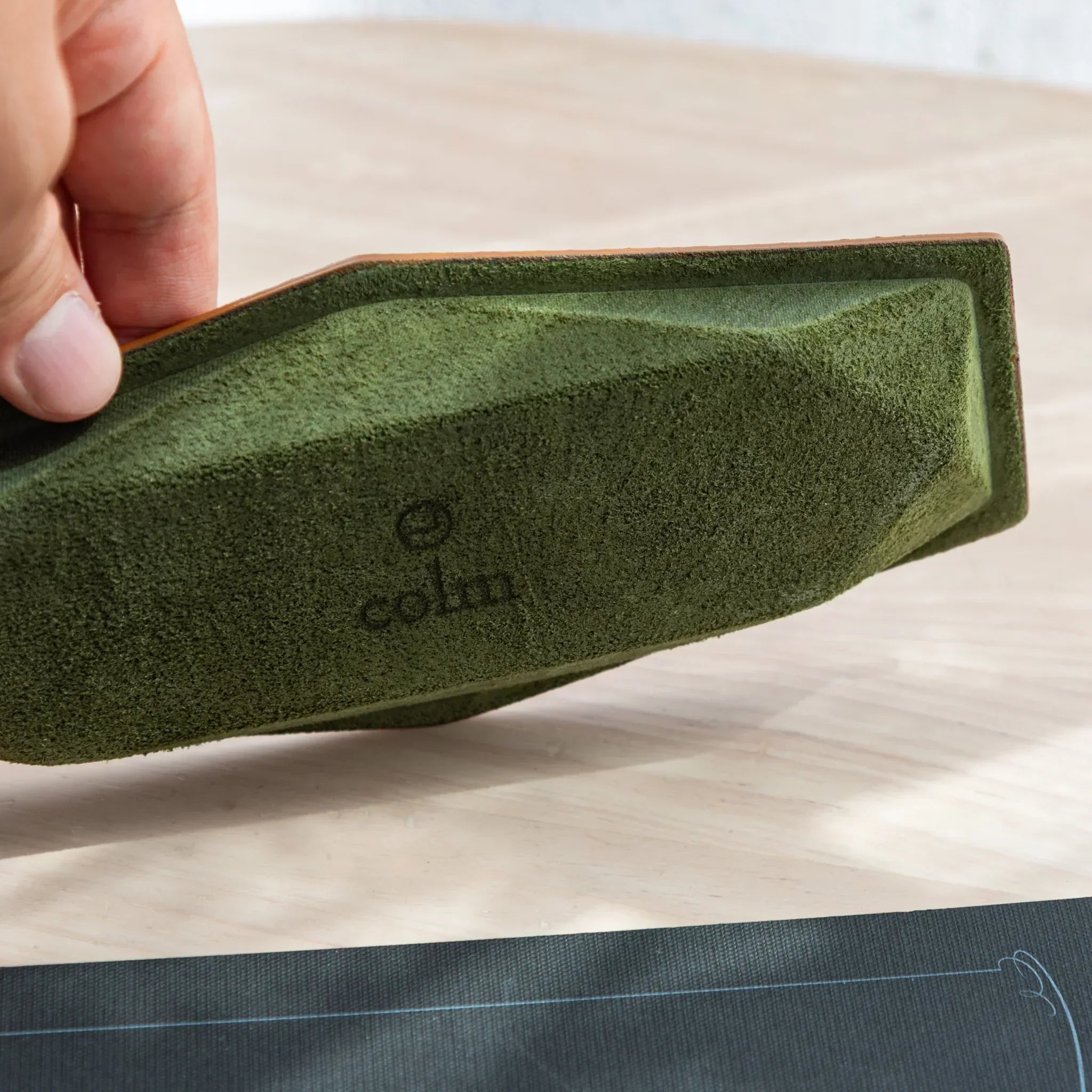 Underside of Japanese Pen Tray made of green suede with colm logo.
