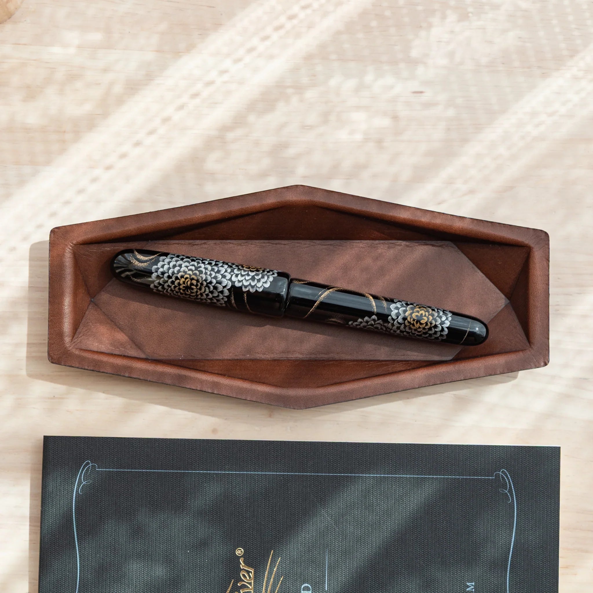 Japanese Fountain Pen placed diagonally inside a dark brown leather hex pen tray.