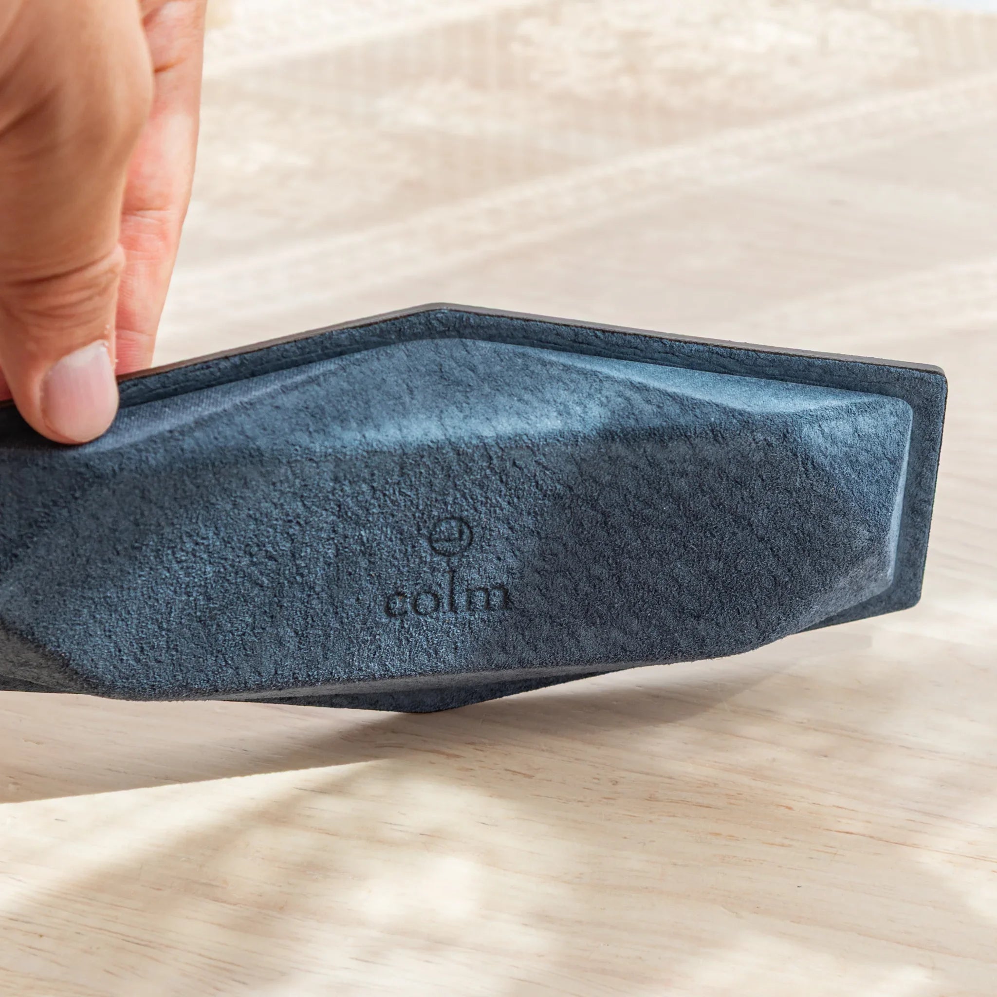Bottom of the Japanese Pen Tray made with Teal-Blue suede and stamped with colm logo.