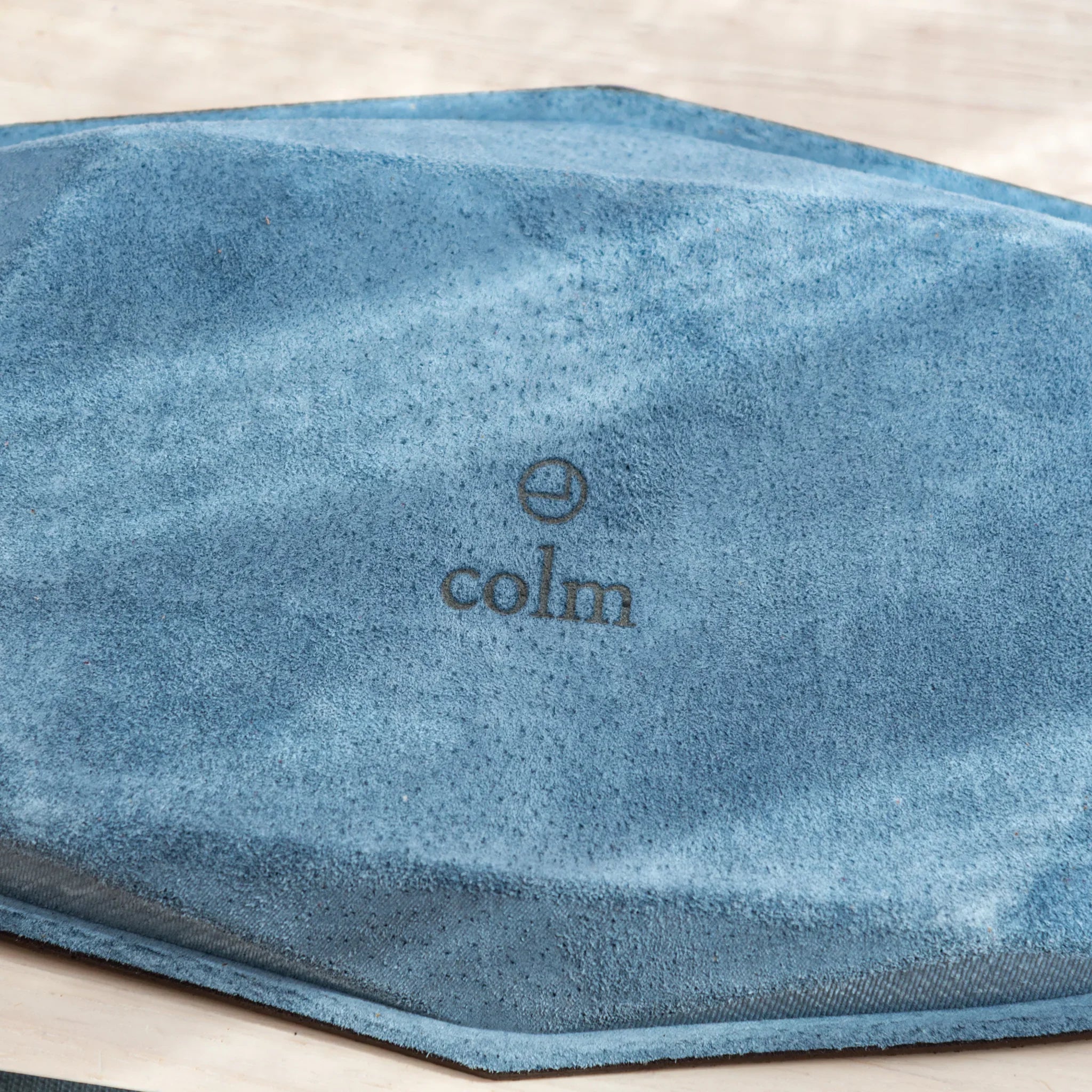 Bottom view of the blue suede Japanese Pen Tray with the colm logo in the center.