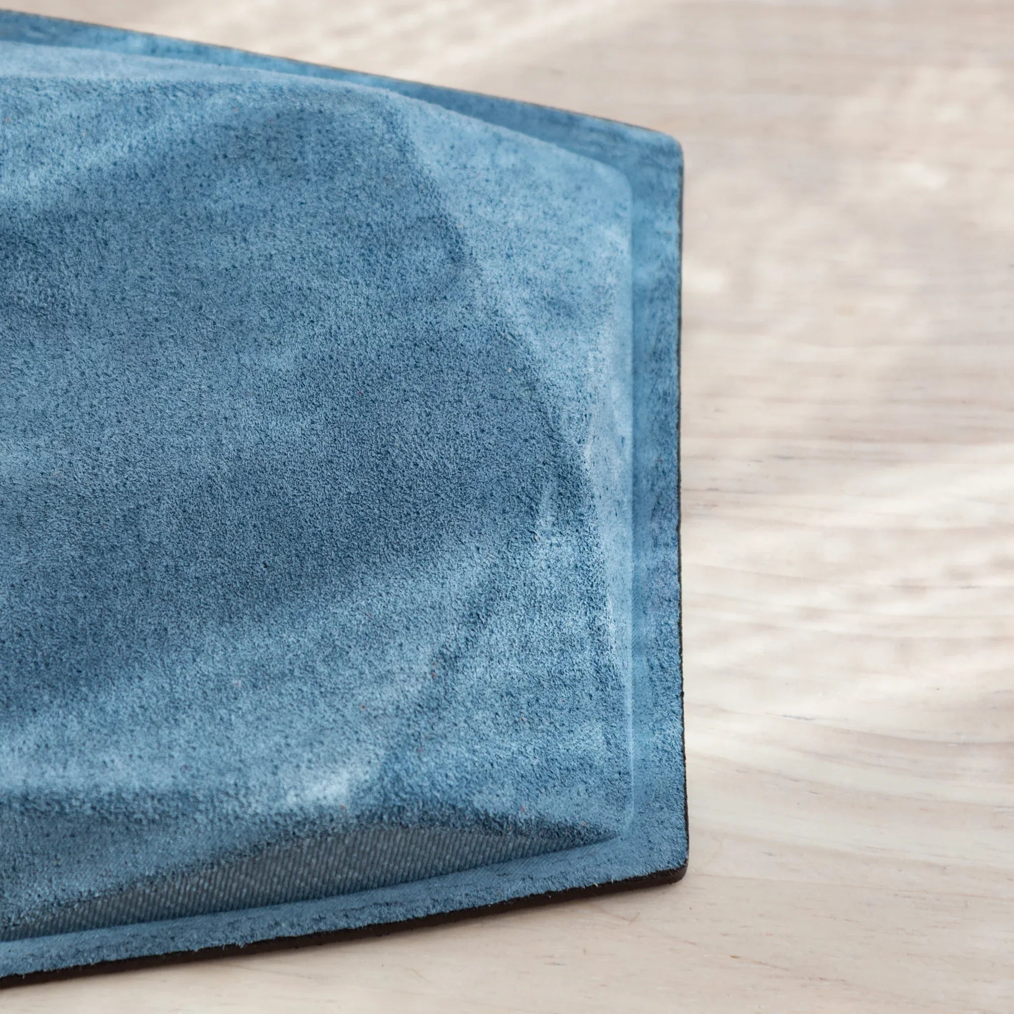 Close-up of the blue suede colm logo stamped on the Japanese Pen Tray bottom.