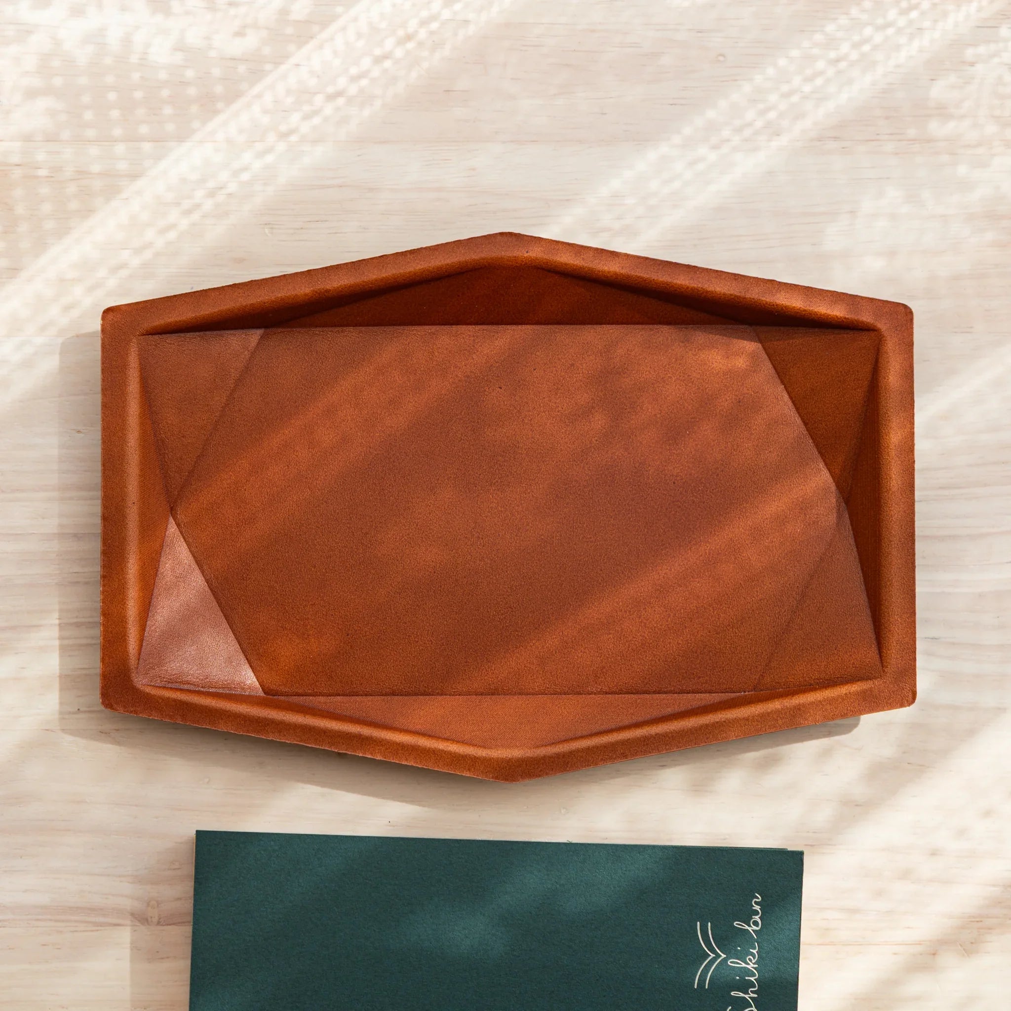 Top view of the camel leather Japanese Pen Tray placed on a wooden desk.