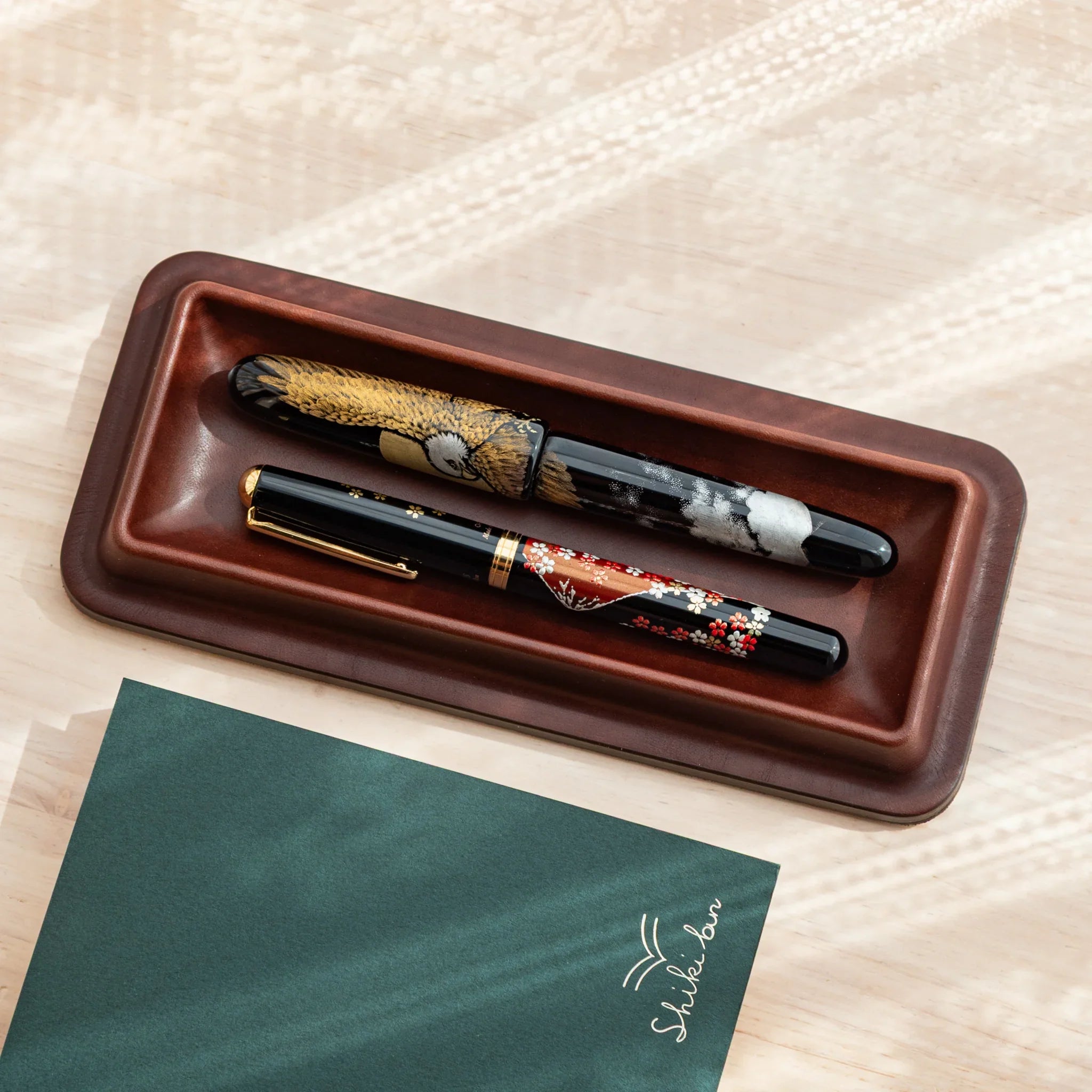 Two Japanese Fountain Pens displayed in brown Tatsuno Leather Pen Tray.