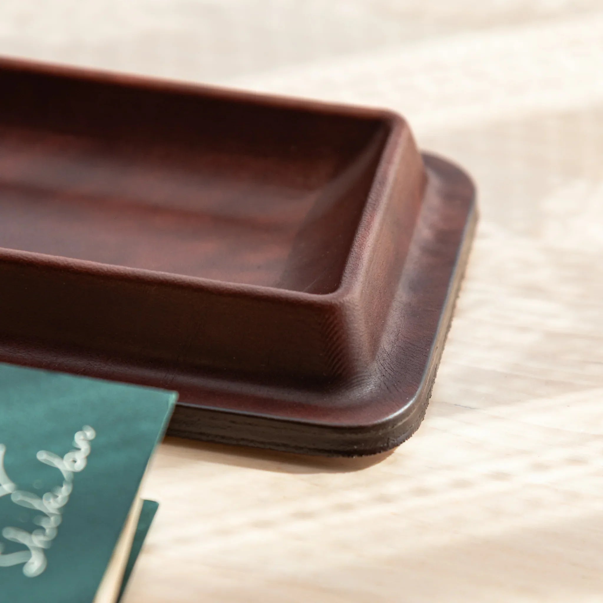 Close-up of the corner of brown Tatsuno Leather Pen Tray with smooth edge.