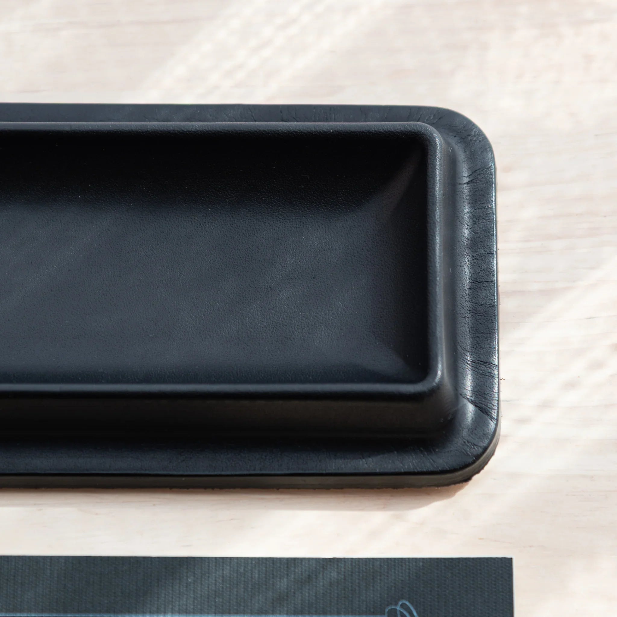 Corner close-up of black Tatsuno Leather Pen Tray showing detailed texture.