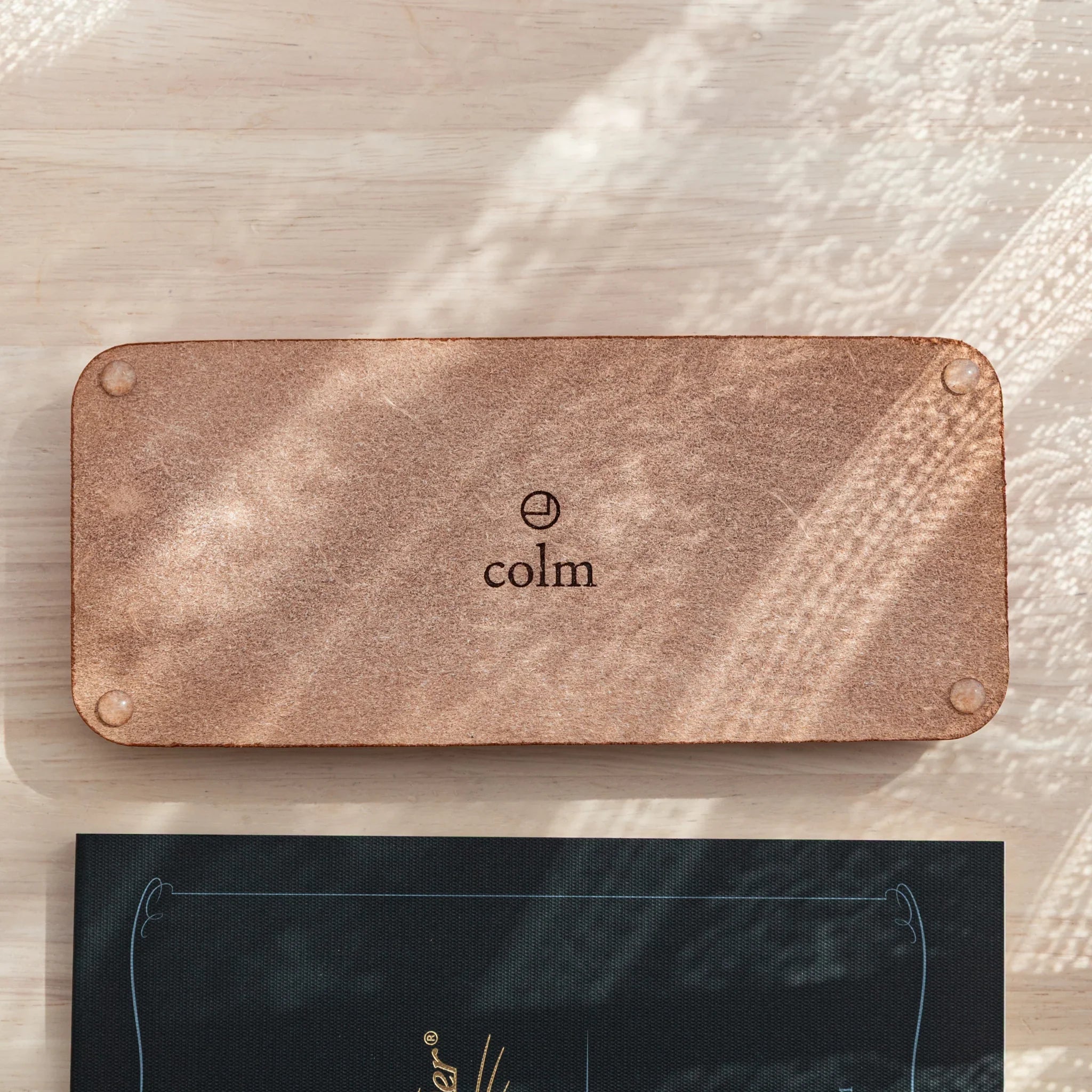 Suede back of Japanese pen tray stamped with the colm logo.