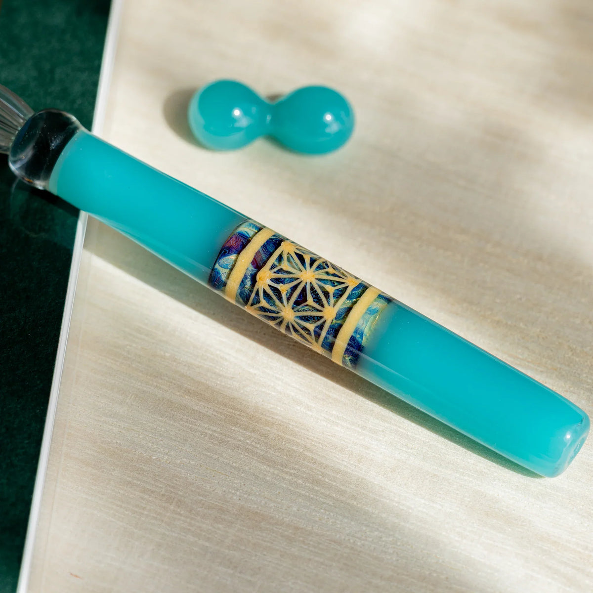 Close-up of the turquoise barrel with a band of blue and cream hemp leaf geometric pattern