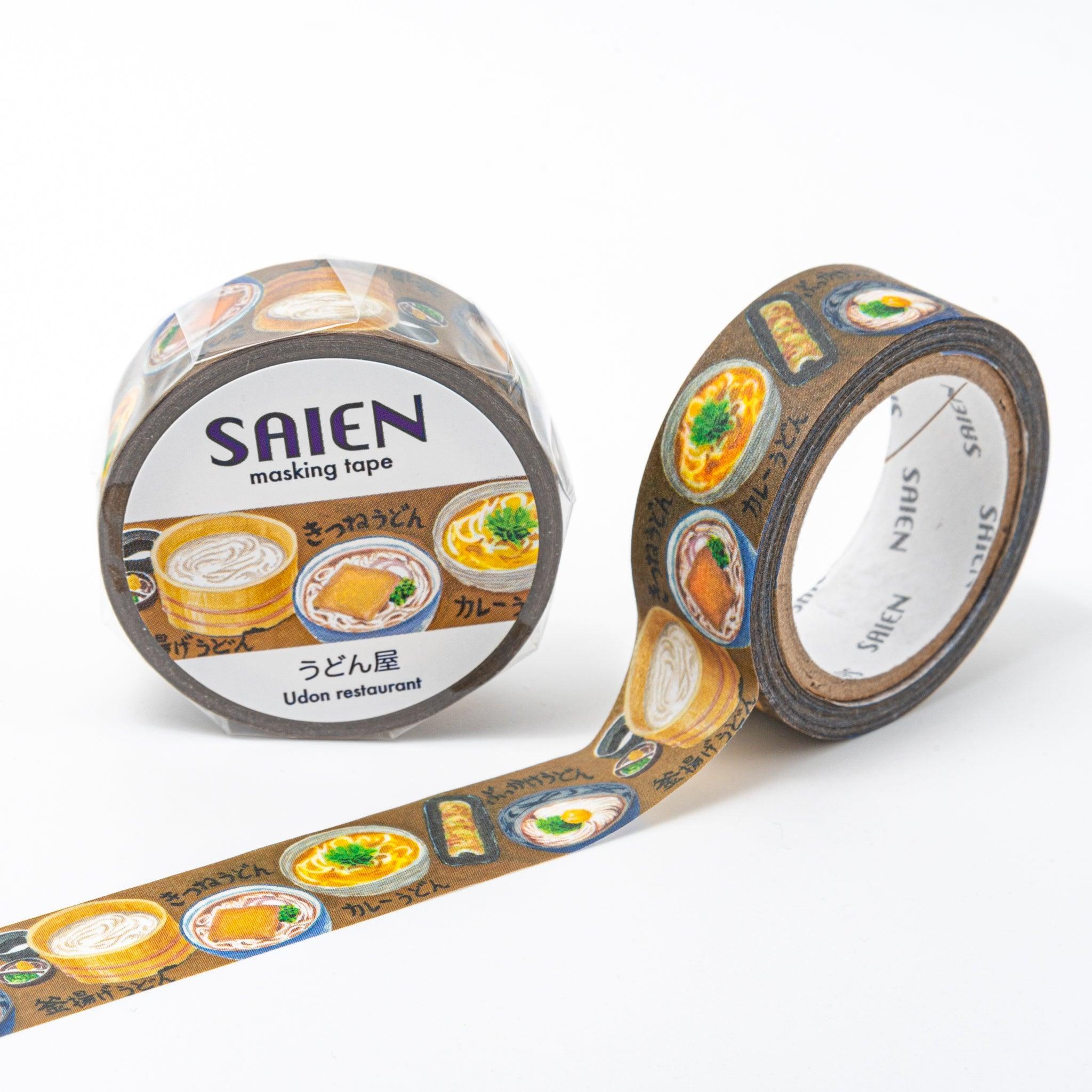 Brown washi tape from Japanese stationery brand SAIEN, featuring illustrations of udon dishes like kitsune udon, curry udon, and other toppings on a dark background.  