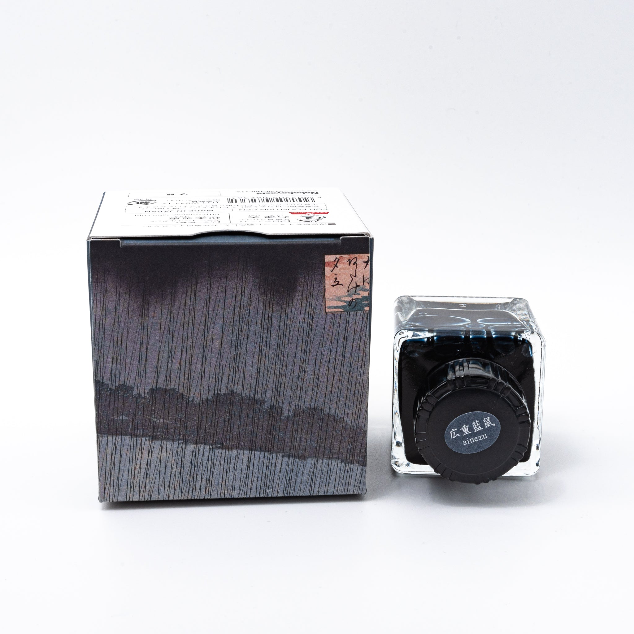 Japanese stationery fountain pen ink. The packaging features Ukiyo-e style art of a rainy bridge scene. The glass bottle contains 40ml of blue-gray "Ainezu" ink.  