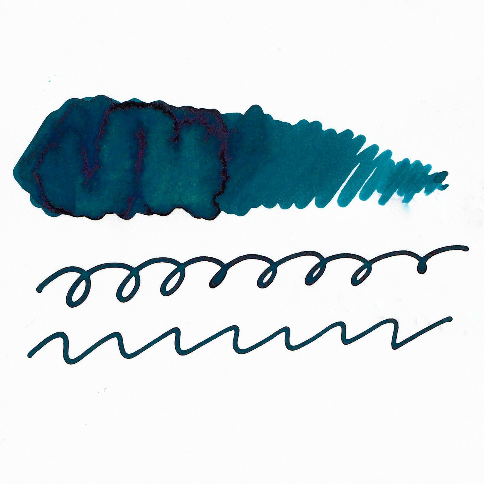 Swatch of teal fountain pen ink on white paper. The ink shows shading variations, with a dark center and lighter edges. Below are wavy and looped lines demonstrating the ink's flow.  