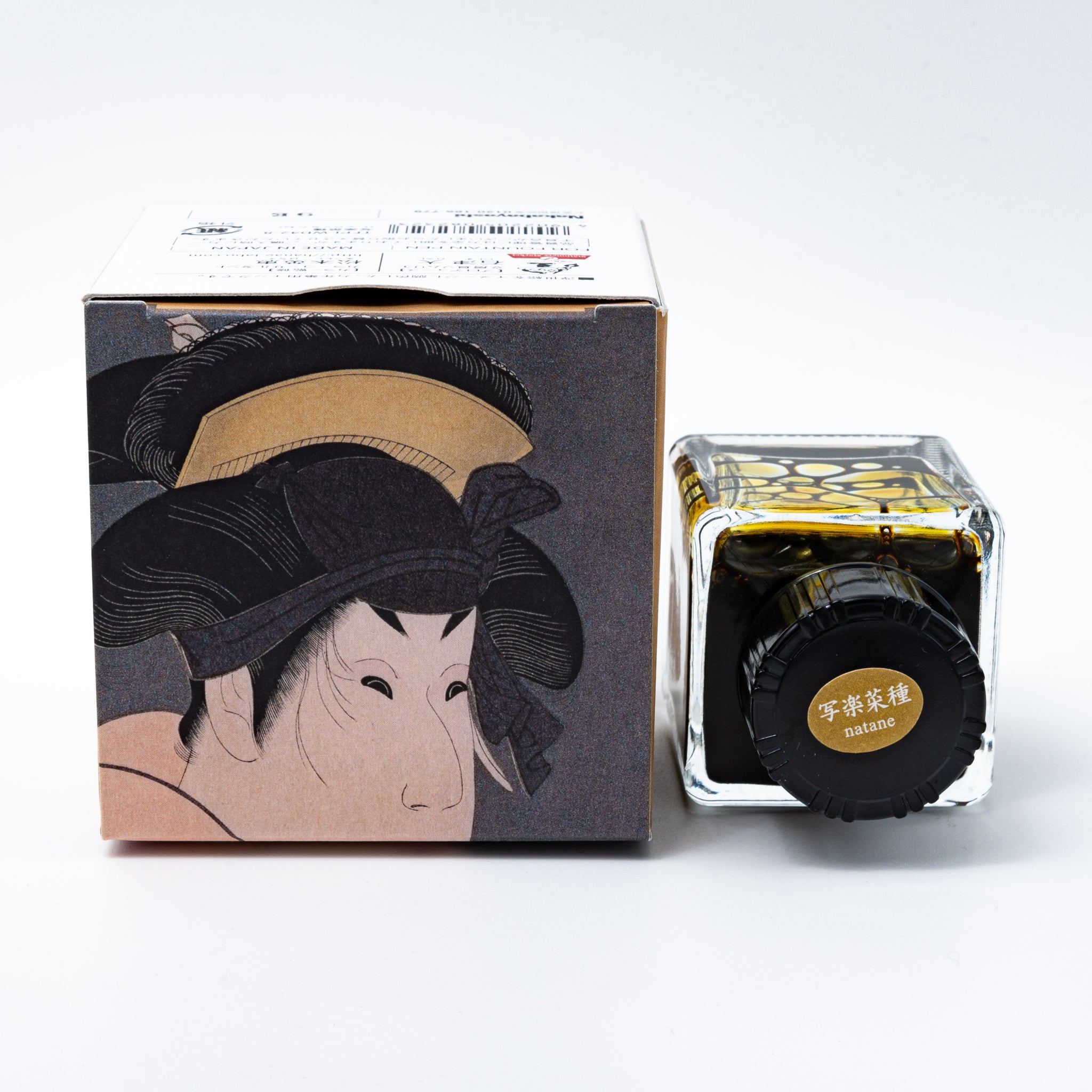 Japanese stationery fountain pen ink. The packaging features Ukiyo-e style art of a kabuki actor in a yellow kimono. The glass bottle contains 40ml of yellow "Natane" ink.  