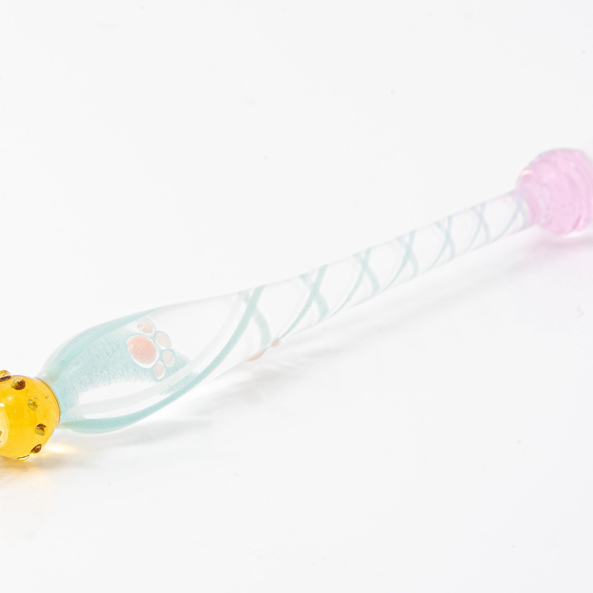 A delicate white glass pen featuring a cat design at the top and a twisted, clear handle, creating a whimsical and elegant look.