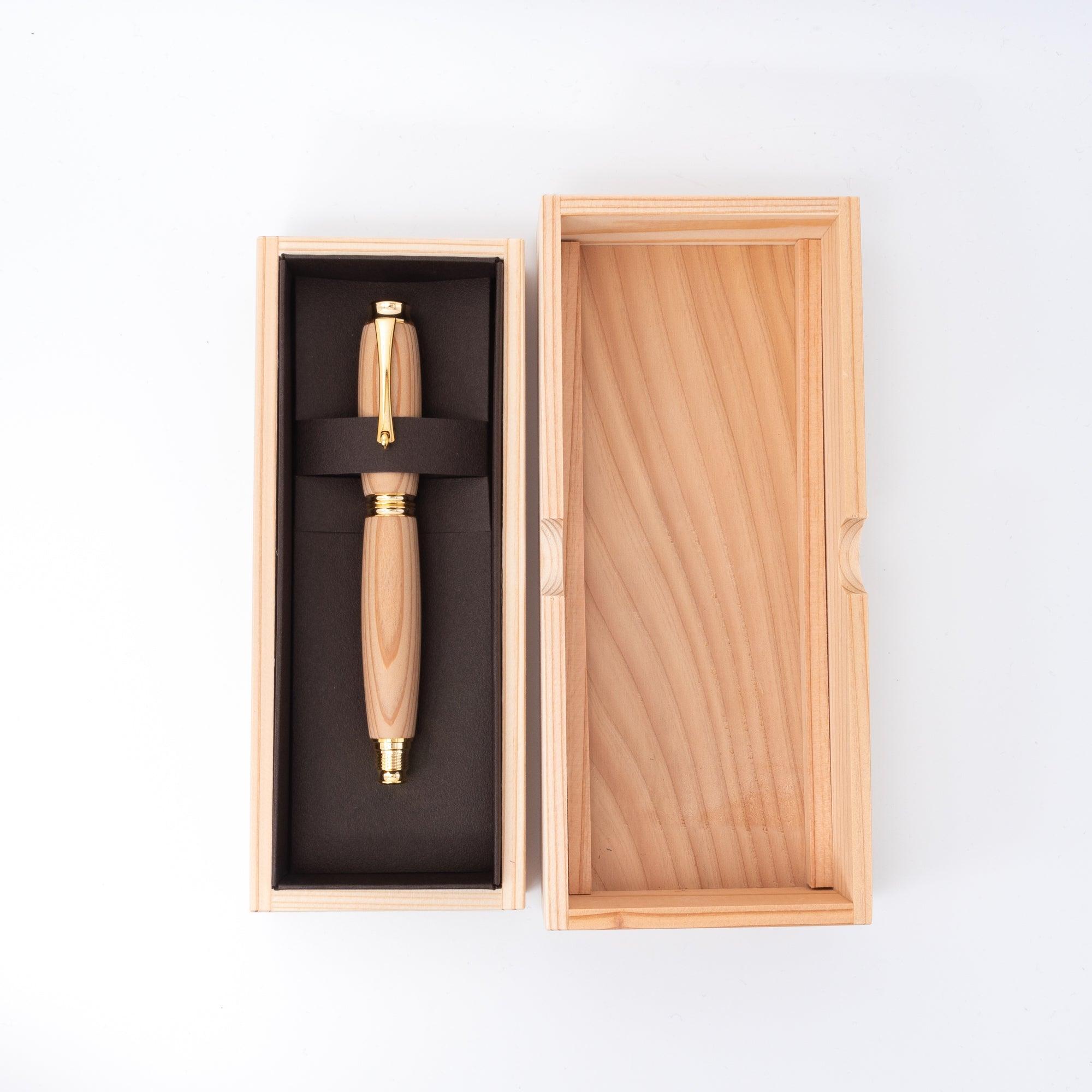 A Yakushima cedar wood fountain pen with gold accents presented in an elegant wooden box, emphasizing its premium design and luxurious craftsmanship.