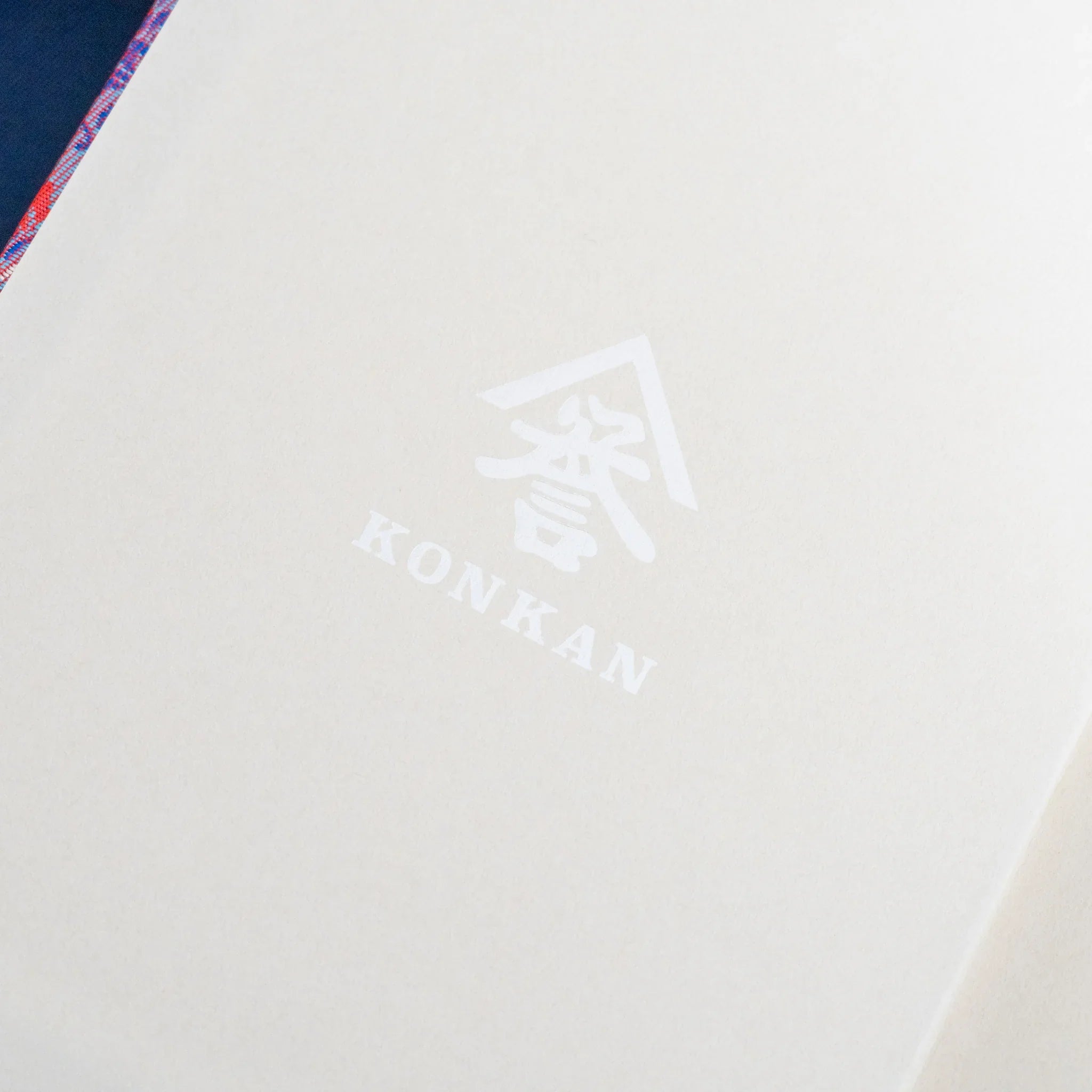Yusoku Hanabishi Nishijin silk notebook inner cover, white page with KONKAN logo print, silk cover corner visible top left