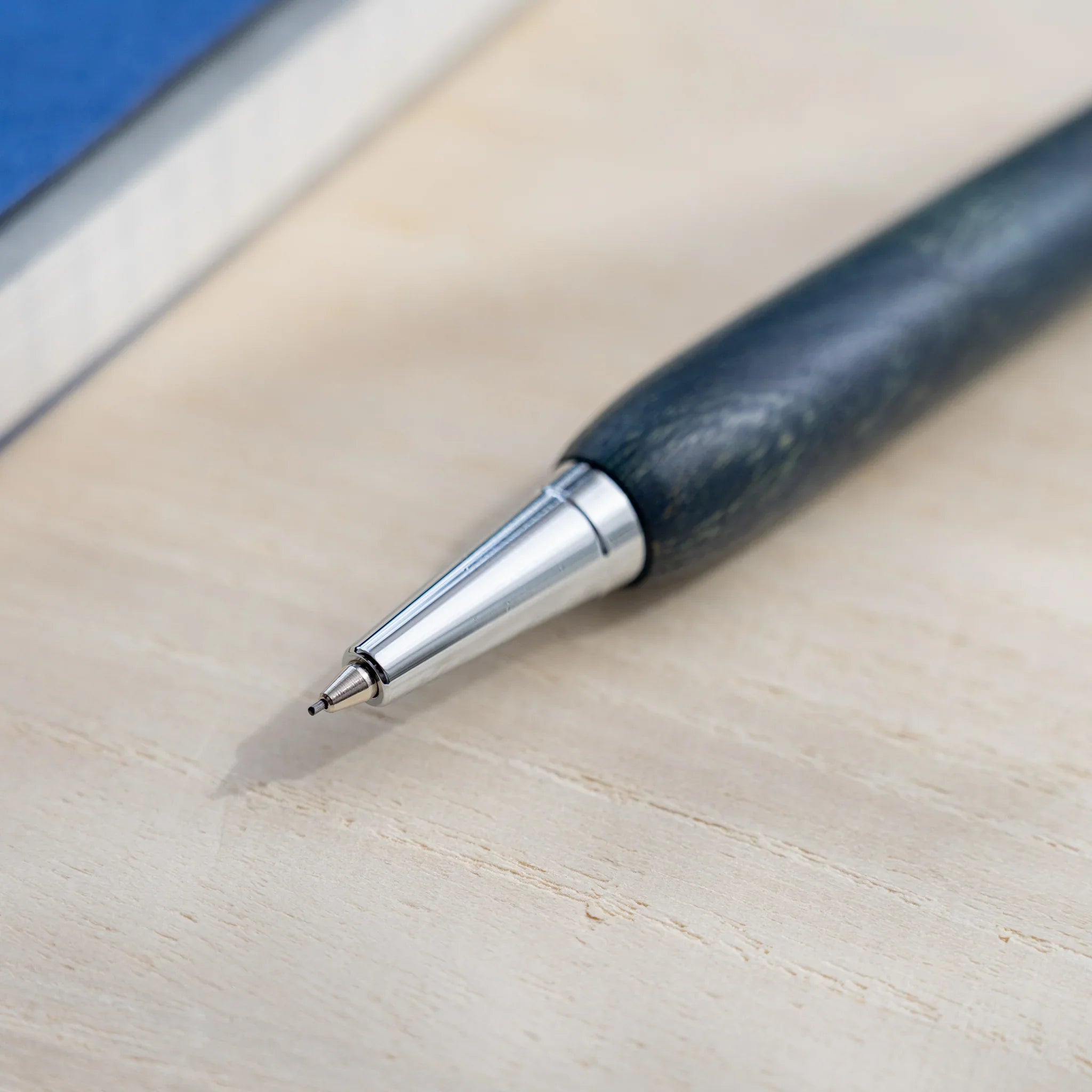 Indigo blue zelkova wood urushi mechanical pencil, close-up of silver cone tip and lead, Japanese keyaki wood