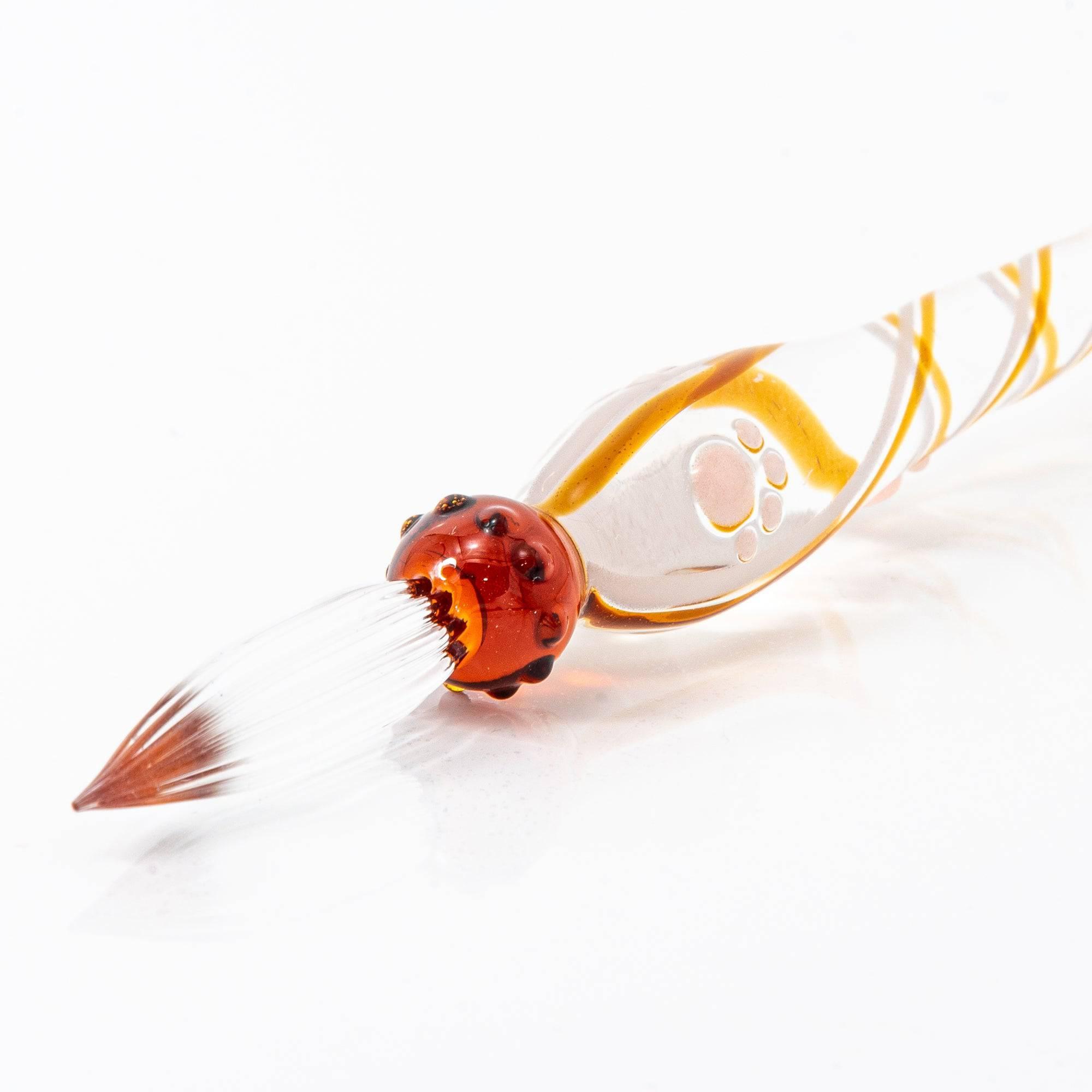 A delicate bworn glass pen featuring a cat design at the top and a twisted, clear handle, creating a whimsical and elegant look.