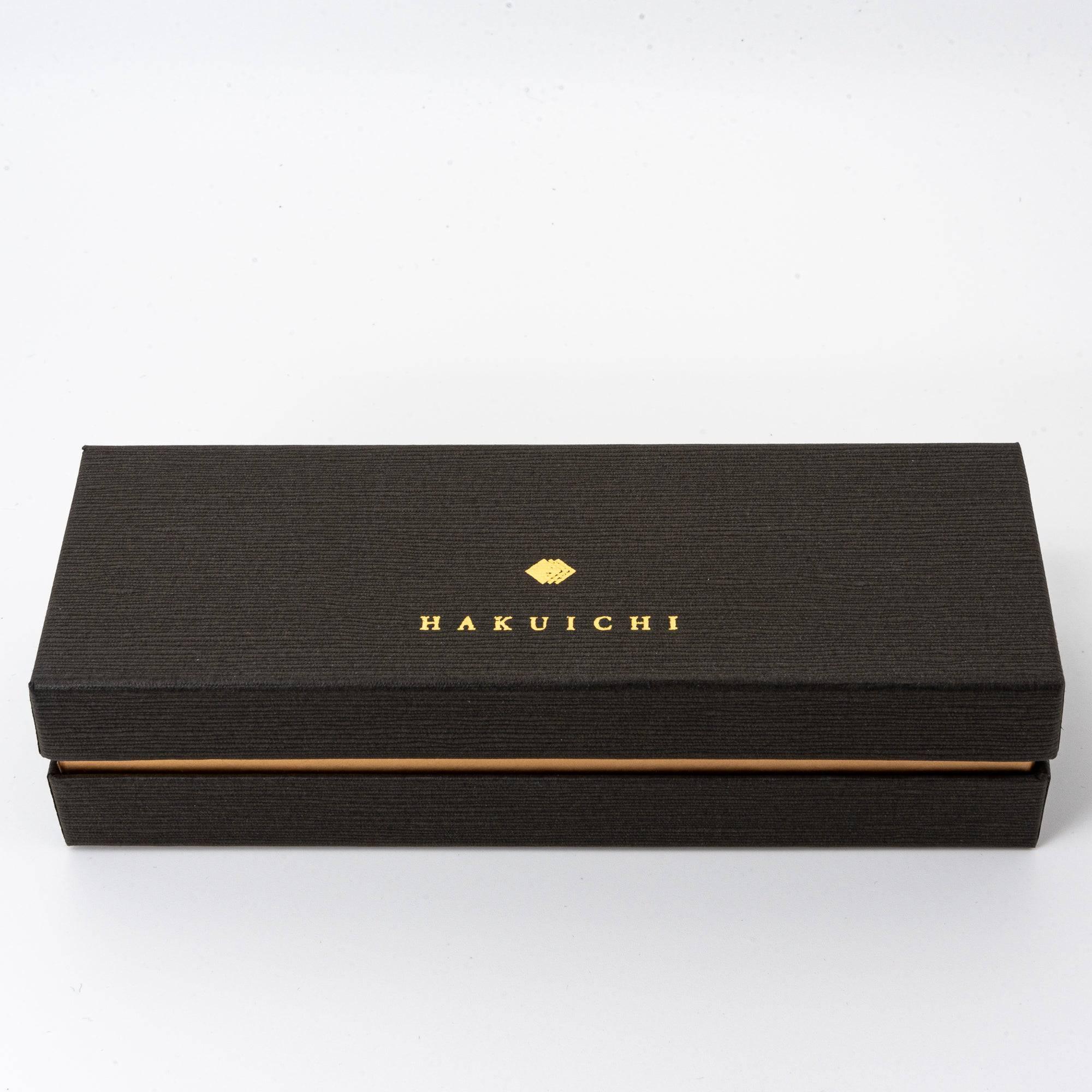 A black Hakuichi box with gold branding, reflecting a minimalist and luxurious packaging design for the pen.