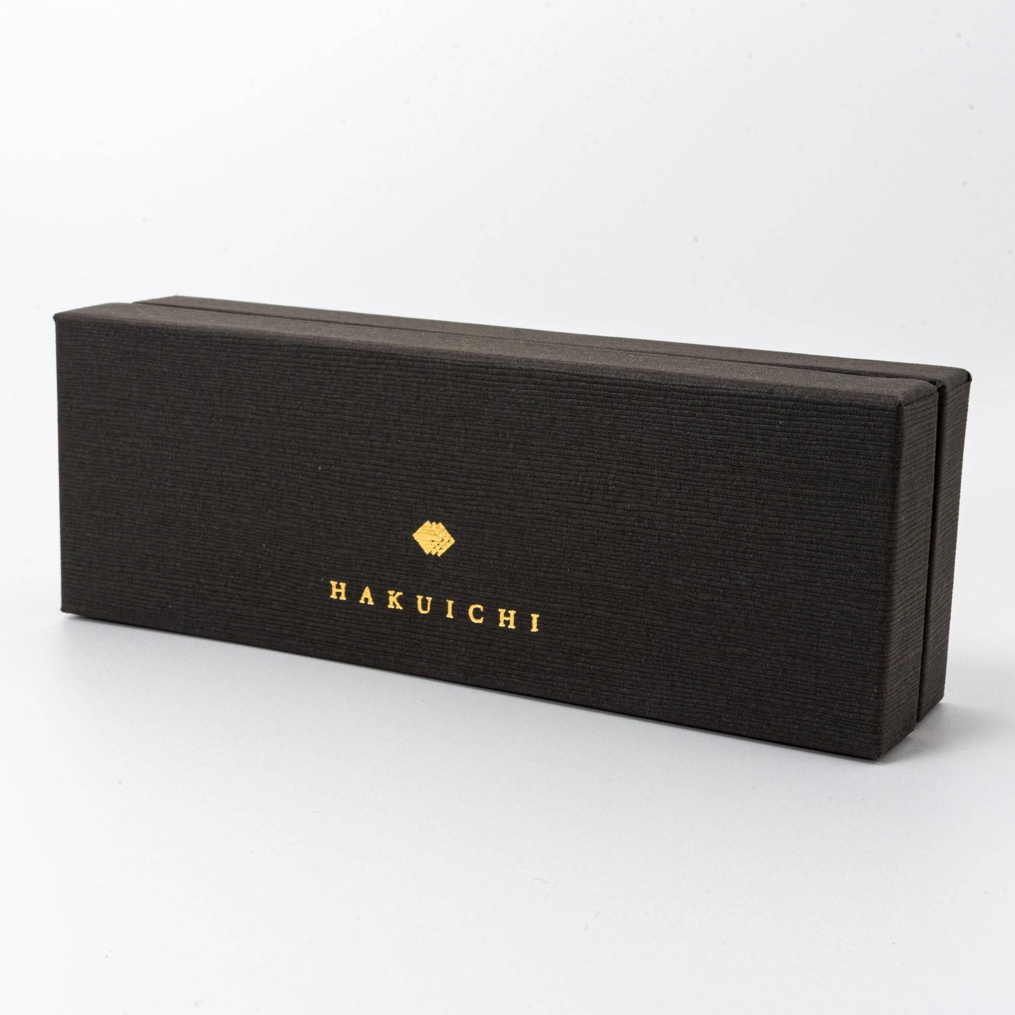 A side view of the black Hakuichi box, featuring gold lettering and a refined textured finish, emphasizing elegance.