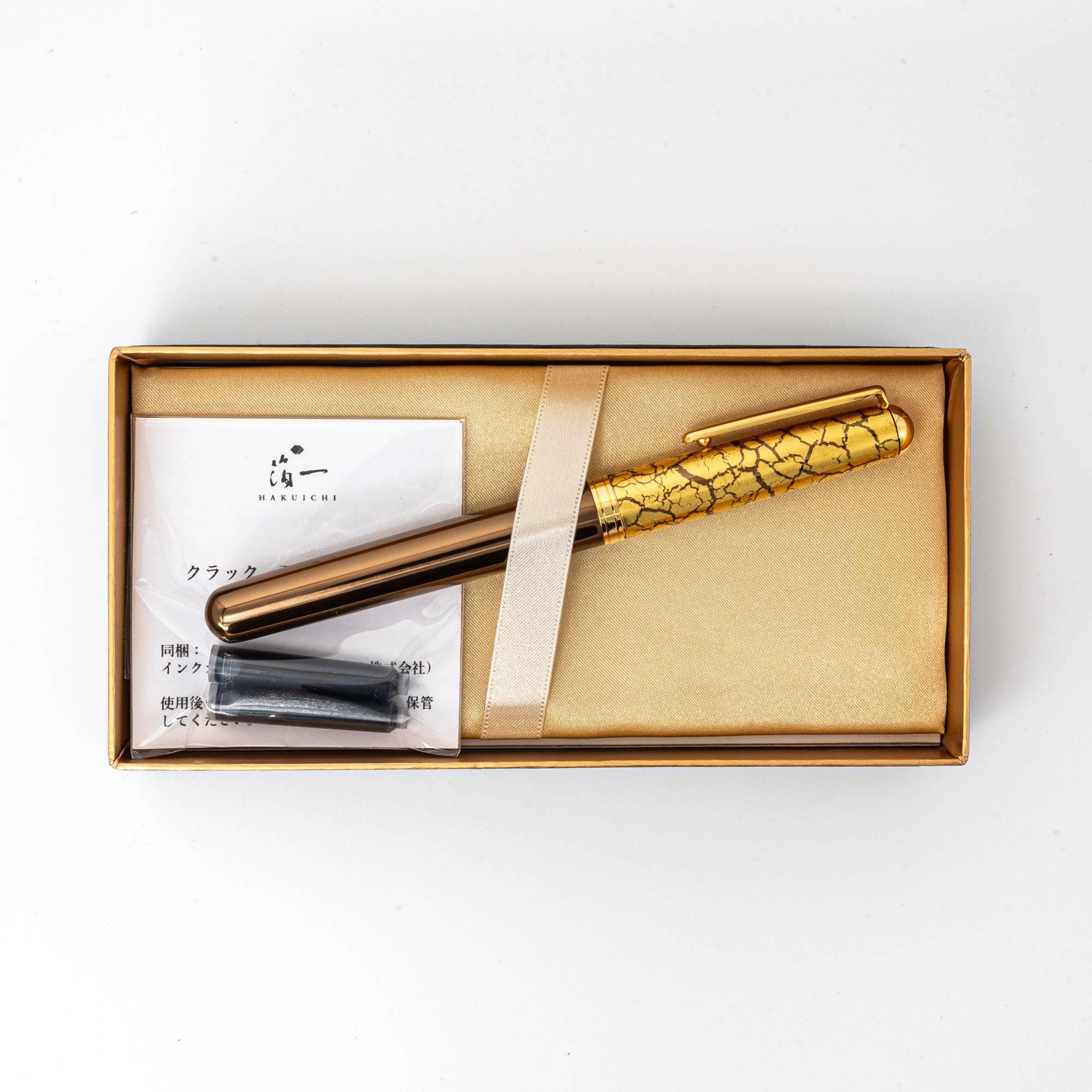 Brown fountain pen presented in a gold-lined gift box, featuring a crackled gold-leaf cap and additional ink cartridges.