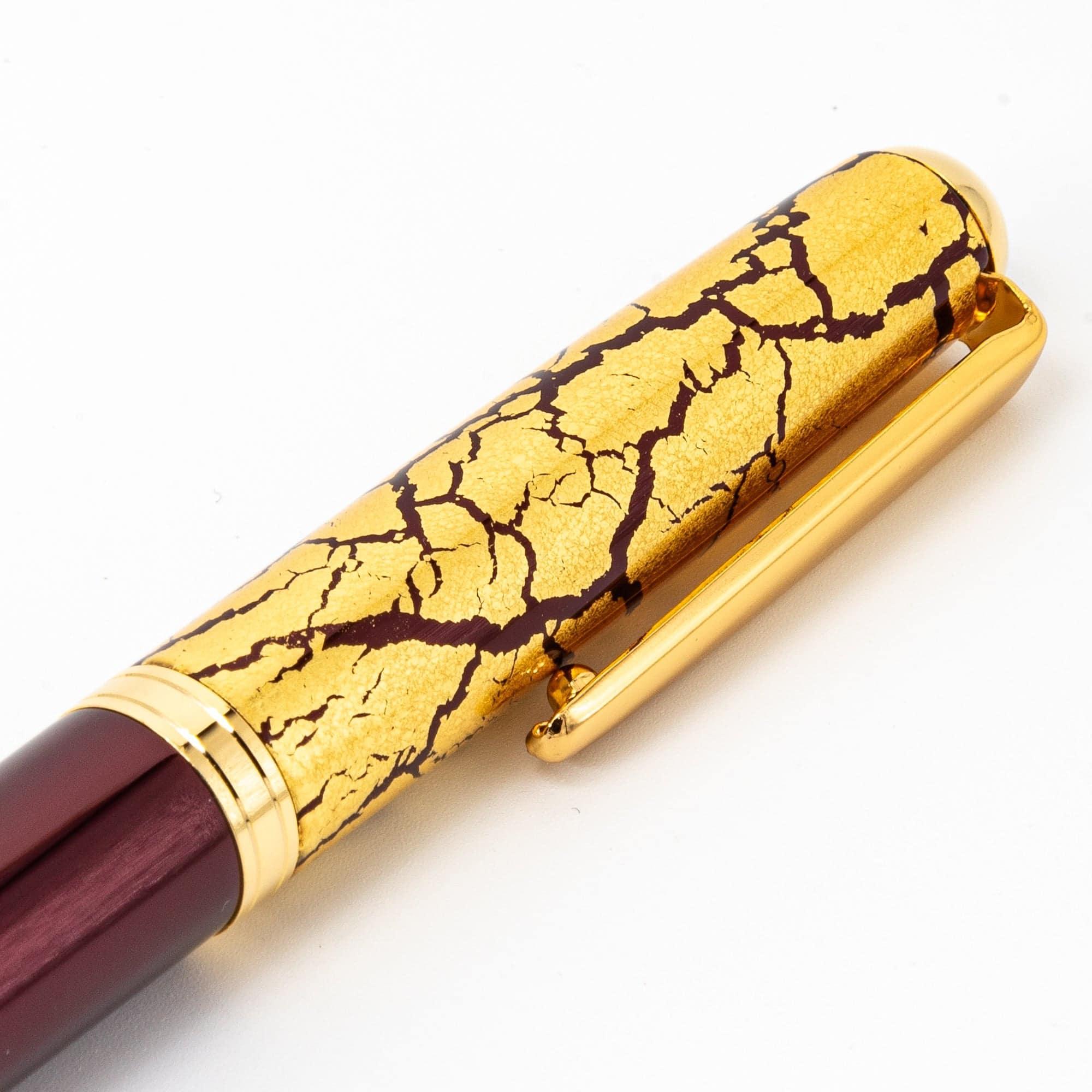 Close-up of the crackled gold-leaf cap on a Japanese fountain pen, showcasing its intricate texture and premium craftsmanship.