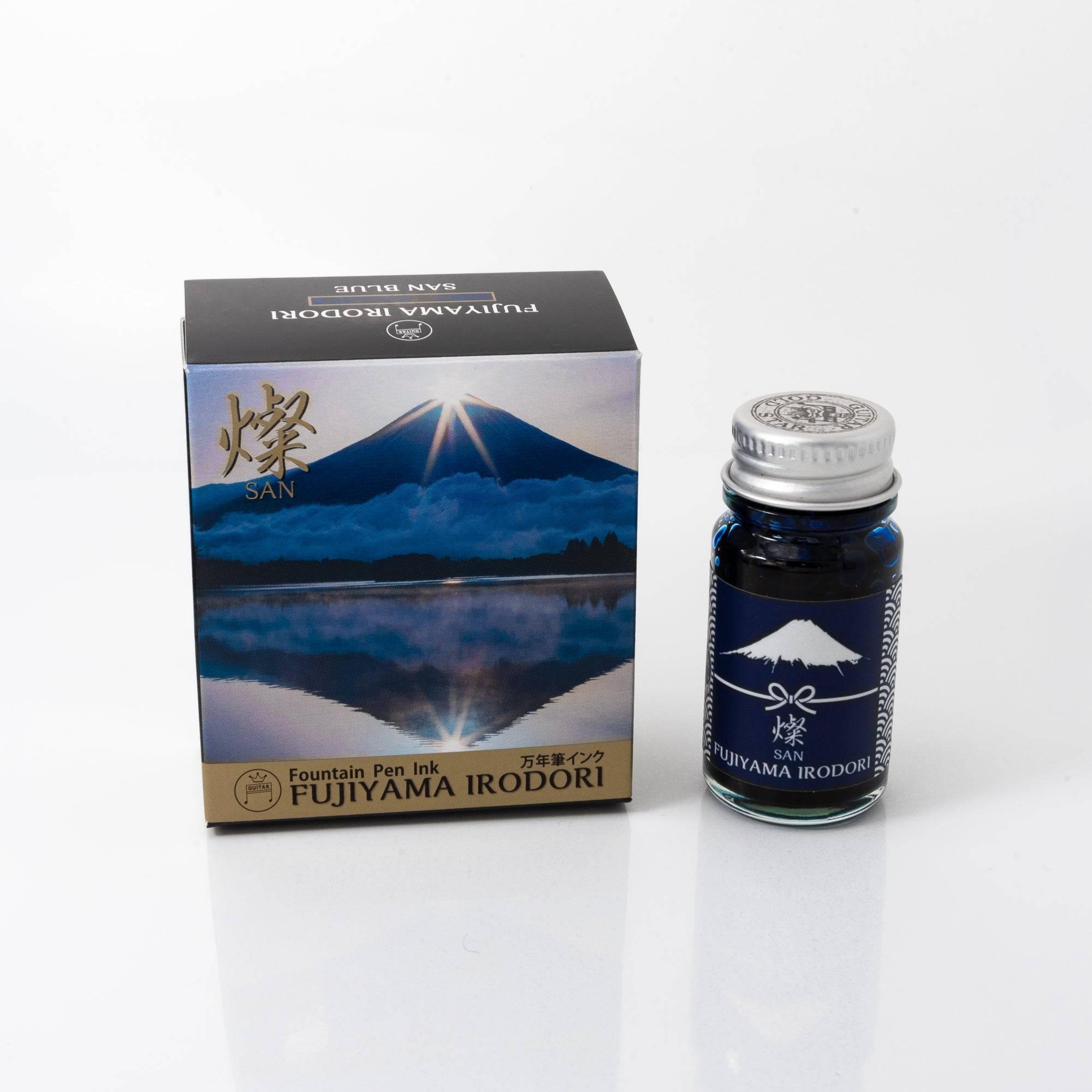 Bottle of Fujiyama Irodori-san fountain pen ink with a minimalist label, placed on a wooden desk under soft natural light.